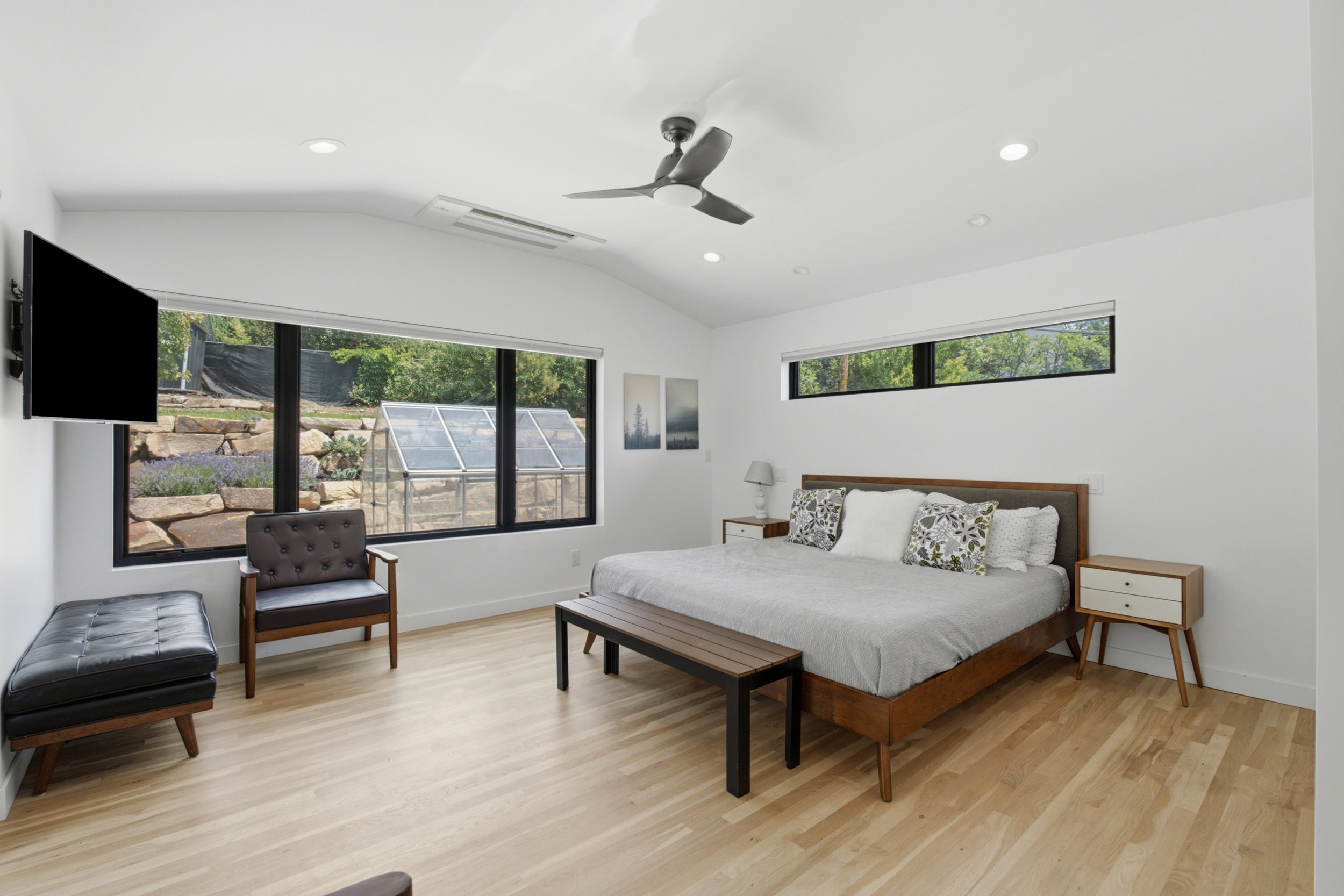 Spacious room featuring vaulted ceilings, recessed lighting, and wood-finish flooring