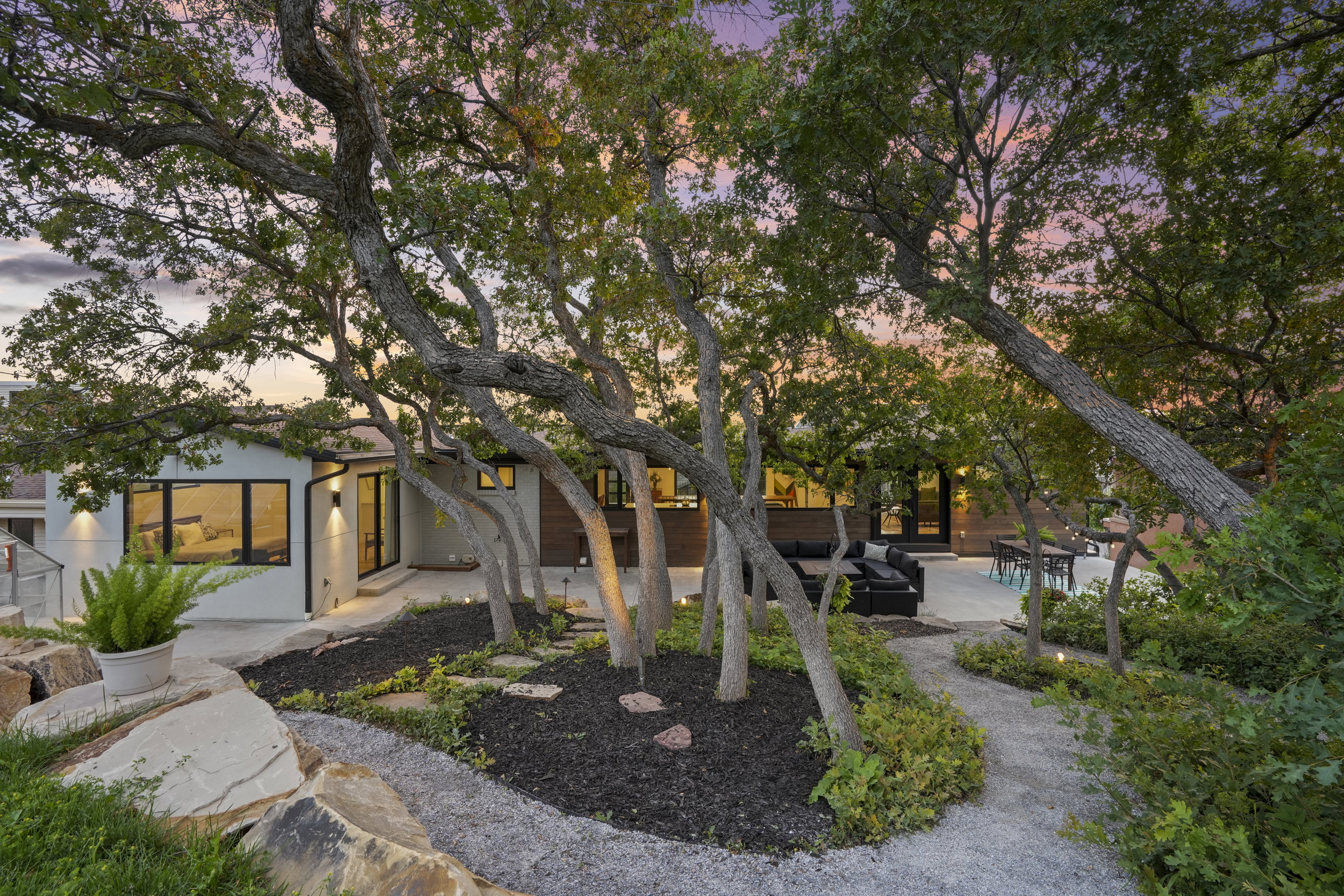 Landscaped exterior featuring mature trees and a gravel pathway