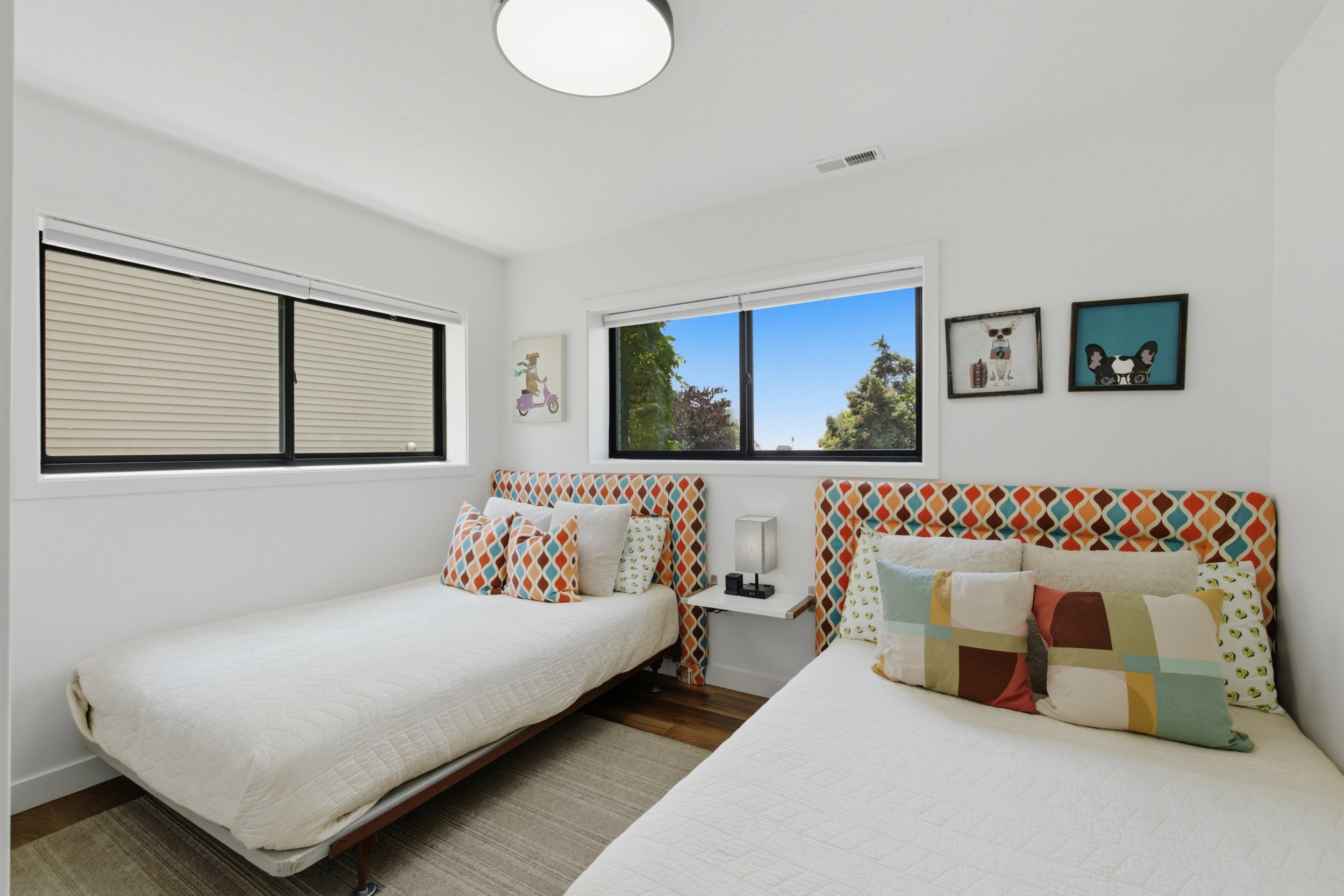Light-filled interior featuring two large windows, one with integrated blinds