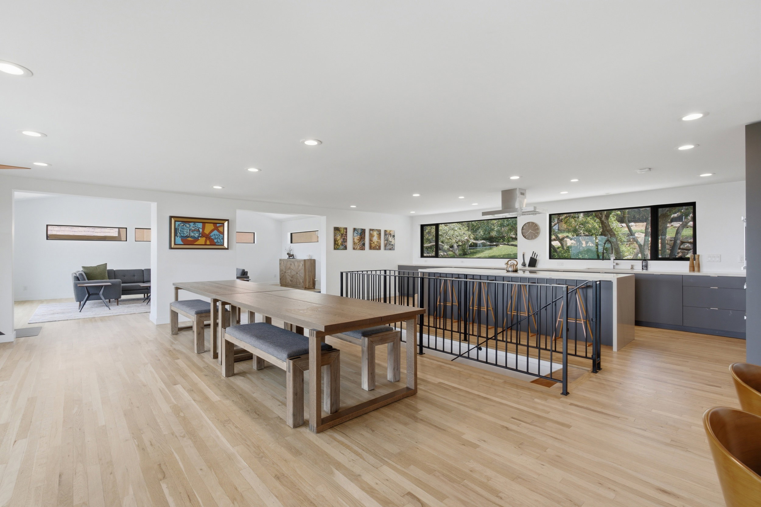 Spacious open-concept interior featuring light wood-finish flooring, recessed lighting, and white walls
