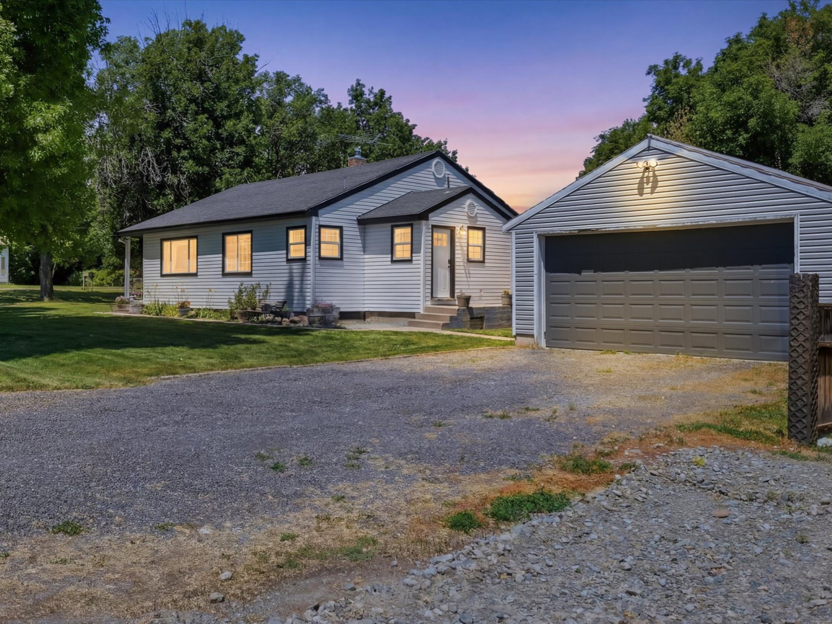 Exterior featuring light-colored siding, a dark roof, and contrasting trim