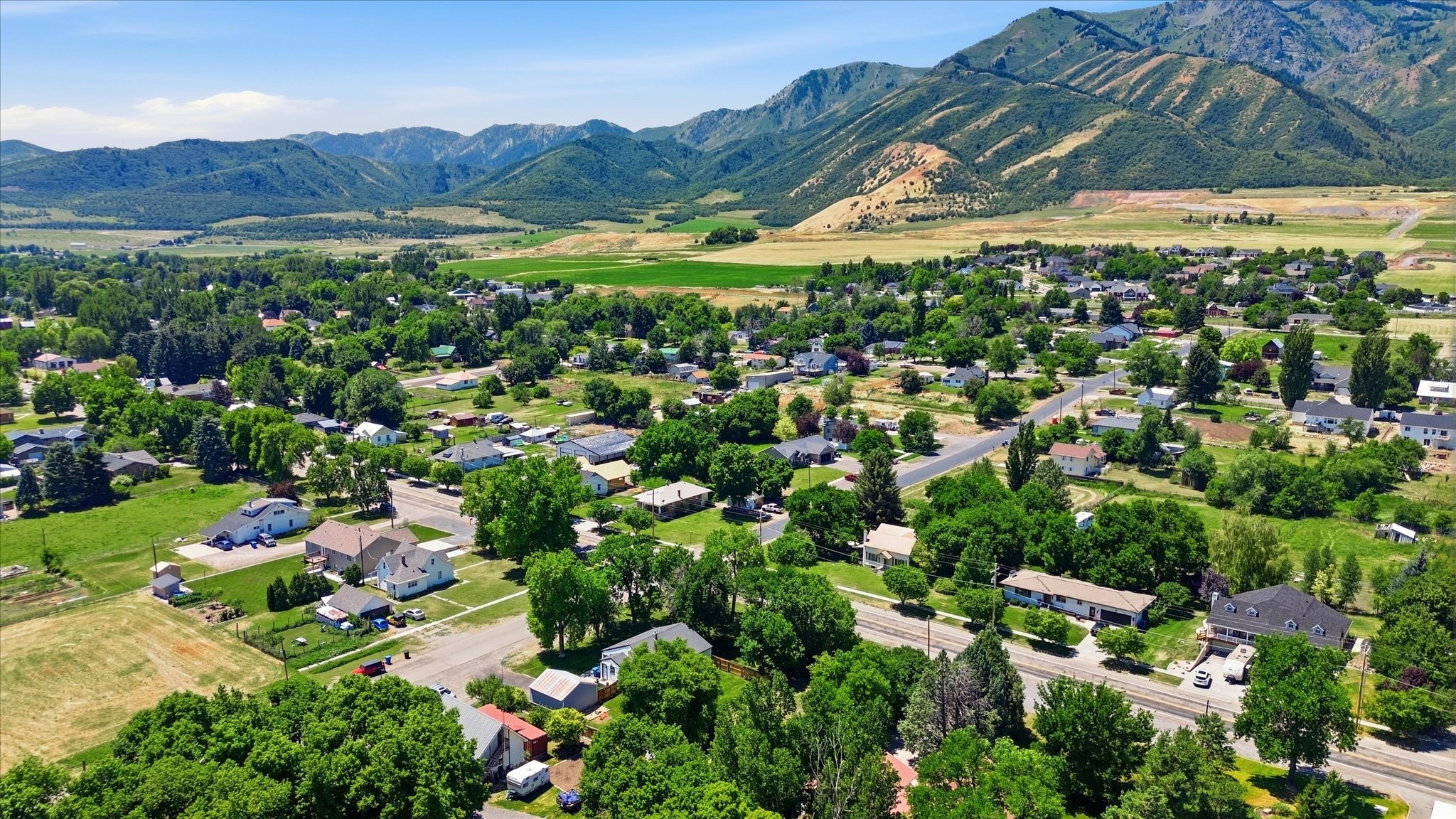 Expansive aerial perspective showcasing a verdant valley setting with a scattering of residential properties