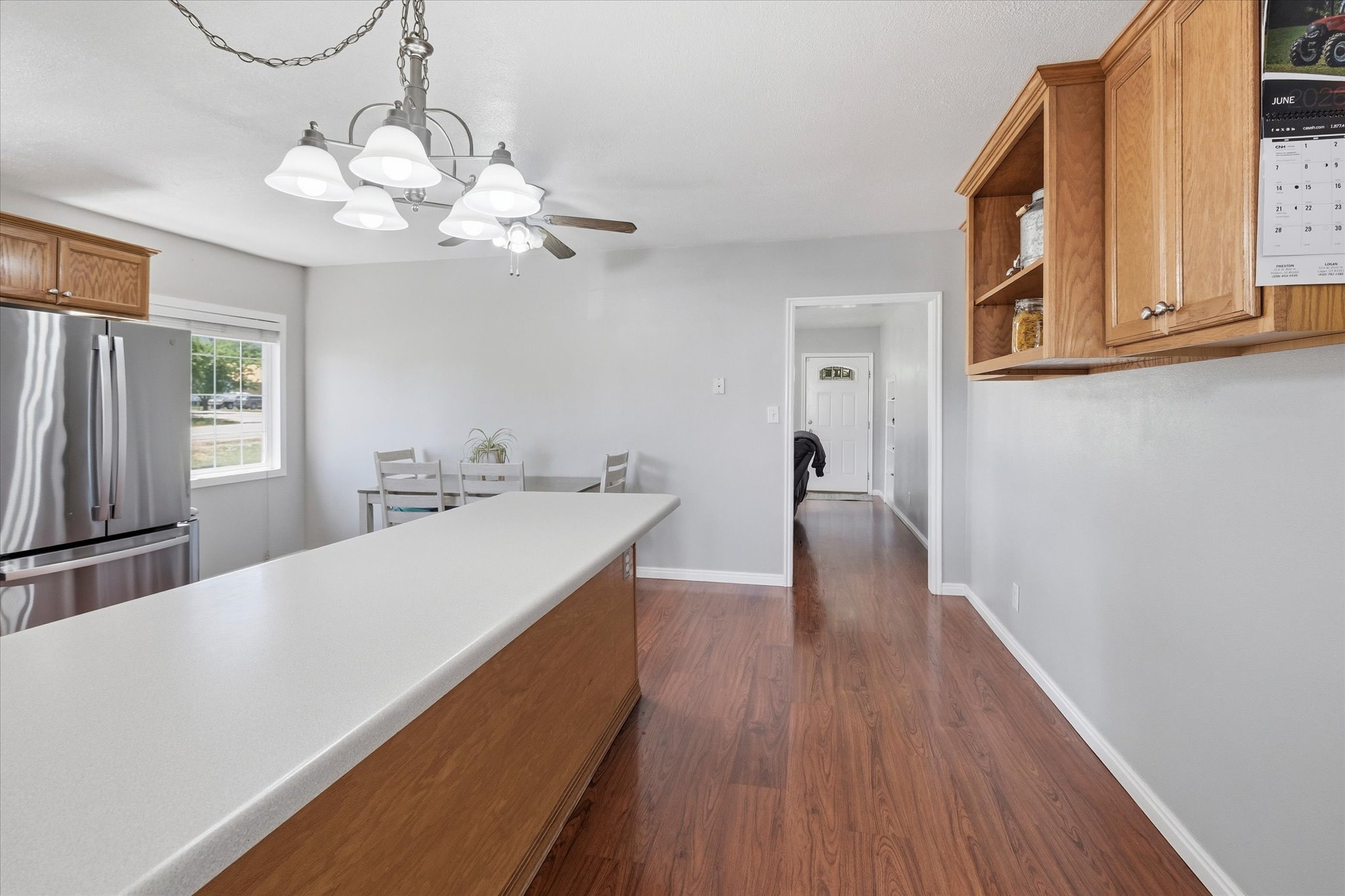 Spacious kitchen featuring a peninsula with a light-toned countertop, wood-finish flooring, and light gray walls