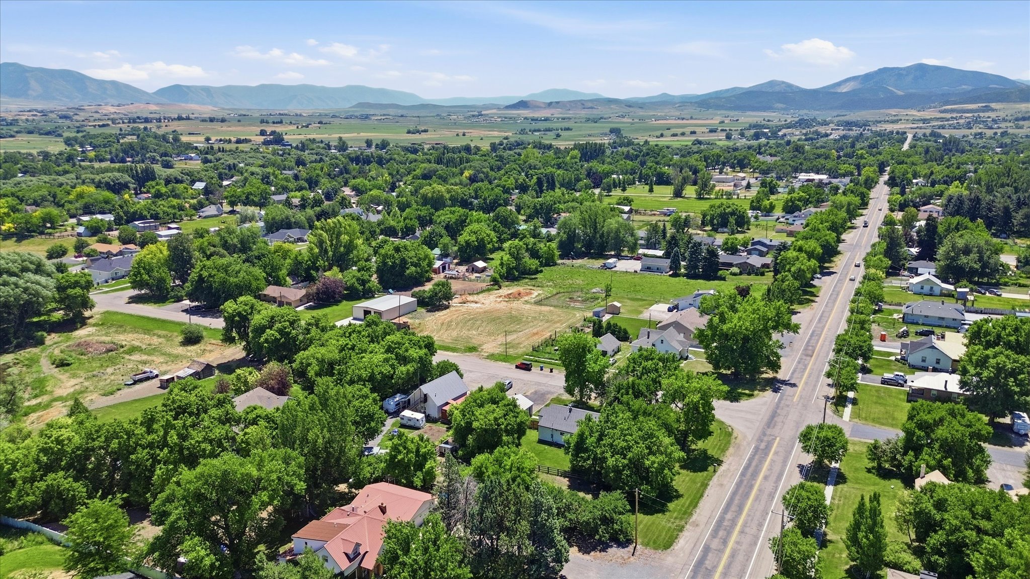 Expansive aerial perspective showcasing a rural community with abundant mature trees and residential properties