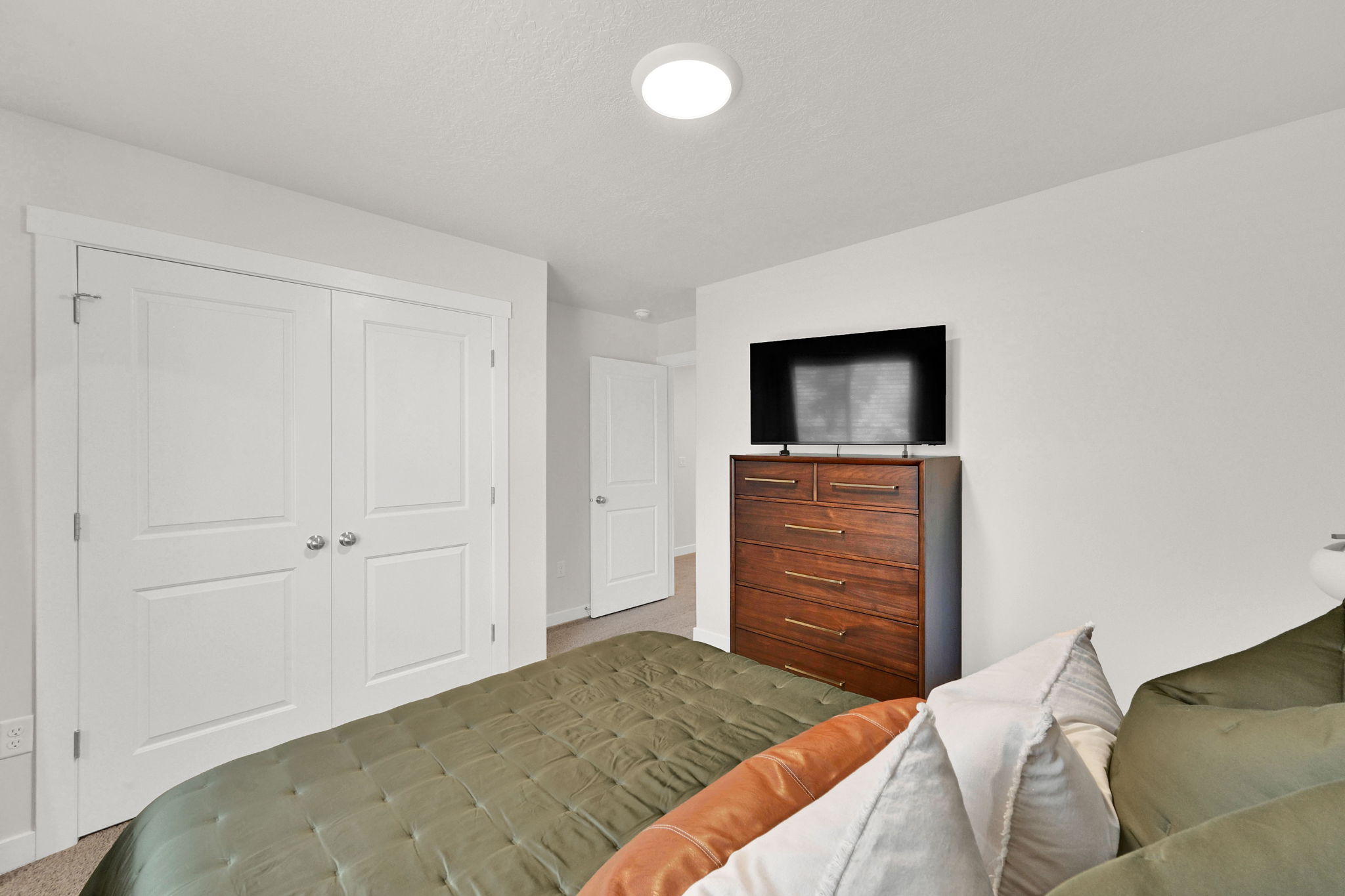 White paneled bi-fold closet doors with chrome hardware