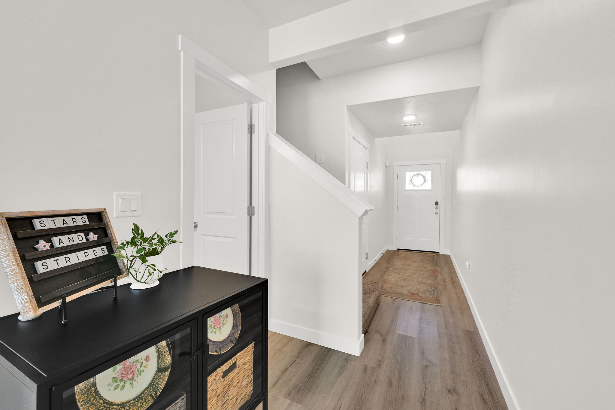Welcoming entry with wood-finish flooring, crisp white walls, and recessed lighting