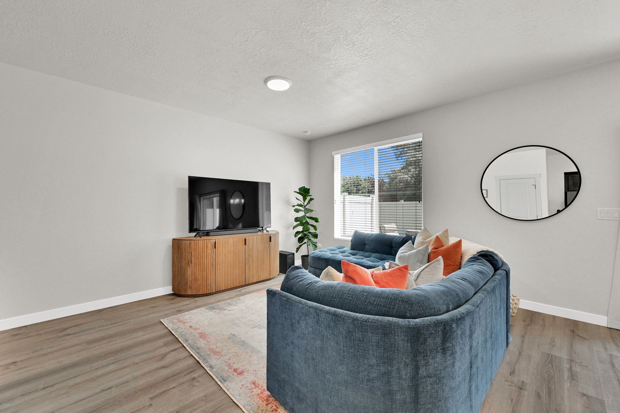 Open living area featuring light gray walls, wood-finish flooring, a contemporary window, and a recessed ceiling light