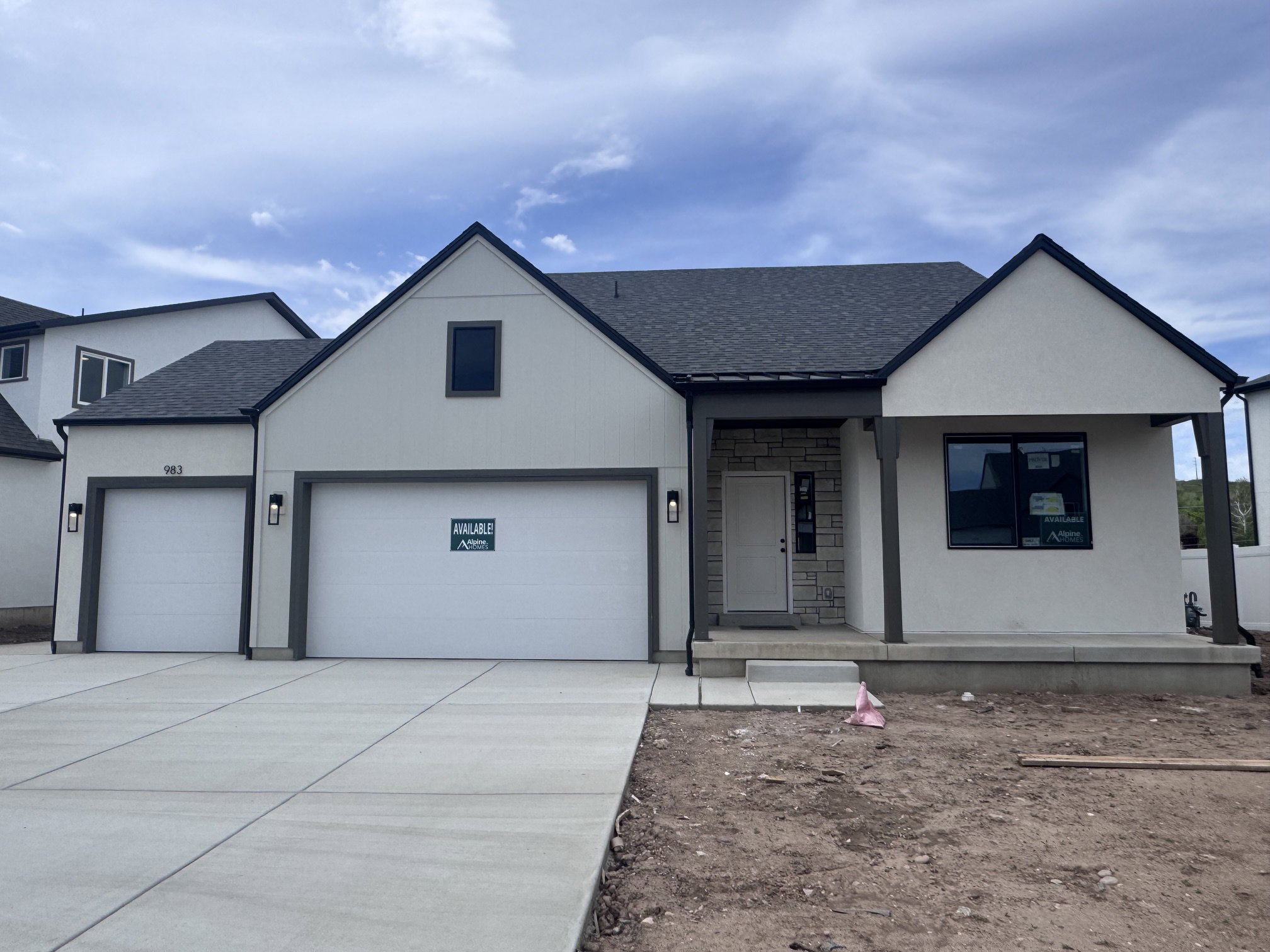 Contemporary exterior featuring white stucco, dark trim accents, and a stone facade entry
