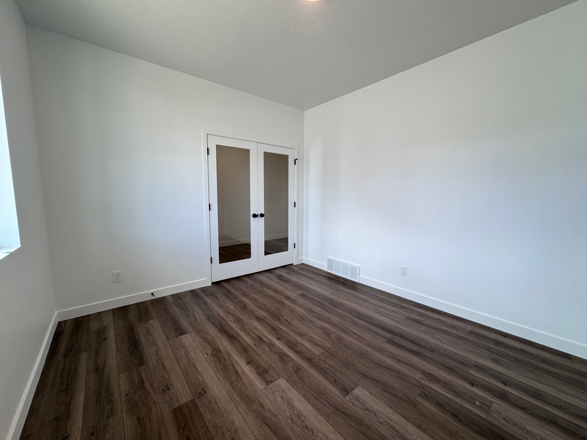 Interior space featuring wood-finish flooring, white walls, and bright white trim