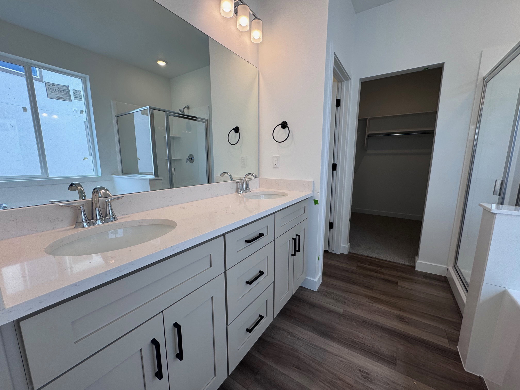 Double vanity with light-toned cabinetry, quartz countertops, and dual undermount sinks
