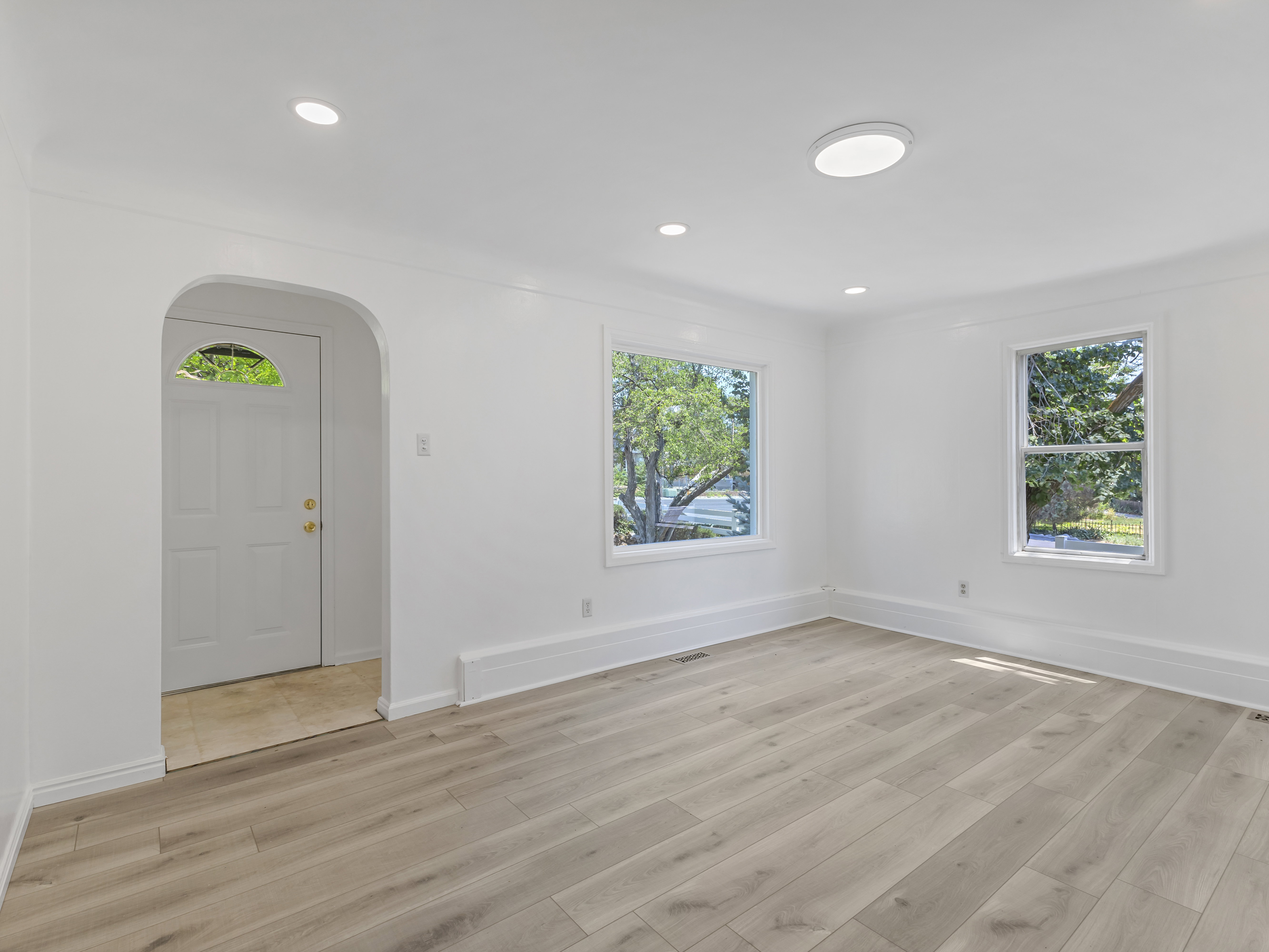 Spacious interior featuring light wood-finish flooring, white walls, and recessed lighting