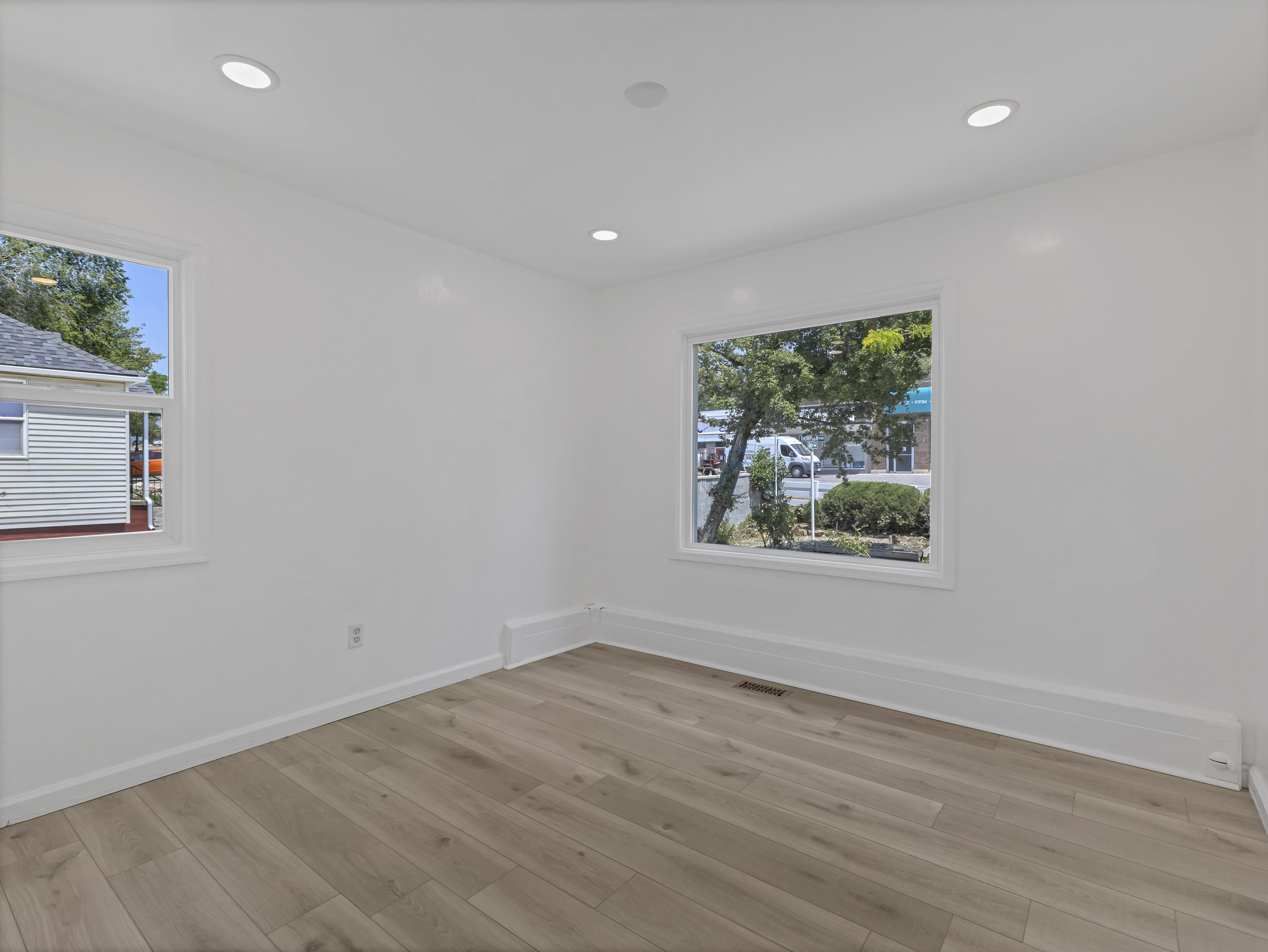 Room featuring light wood-finish flooring, recessed ceiling lighting, and white baseboards