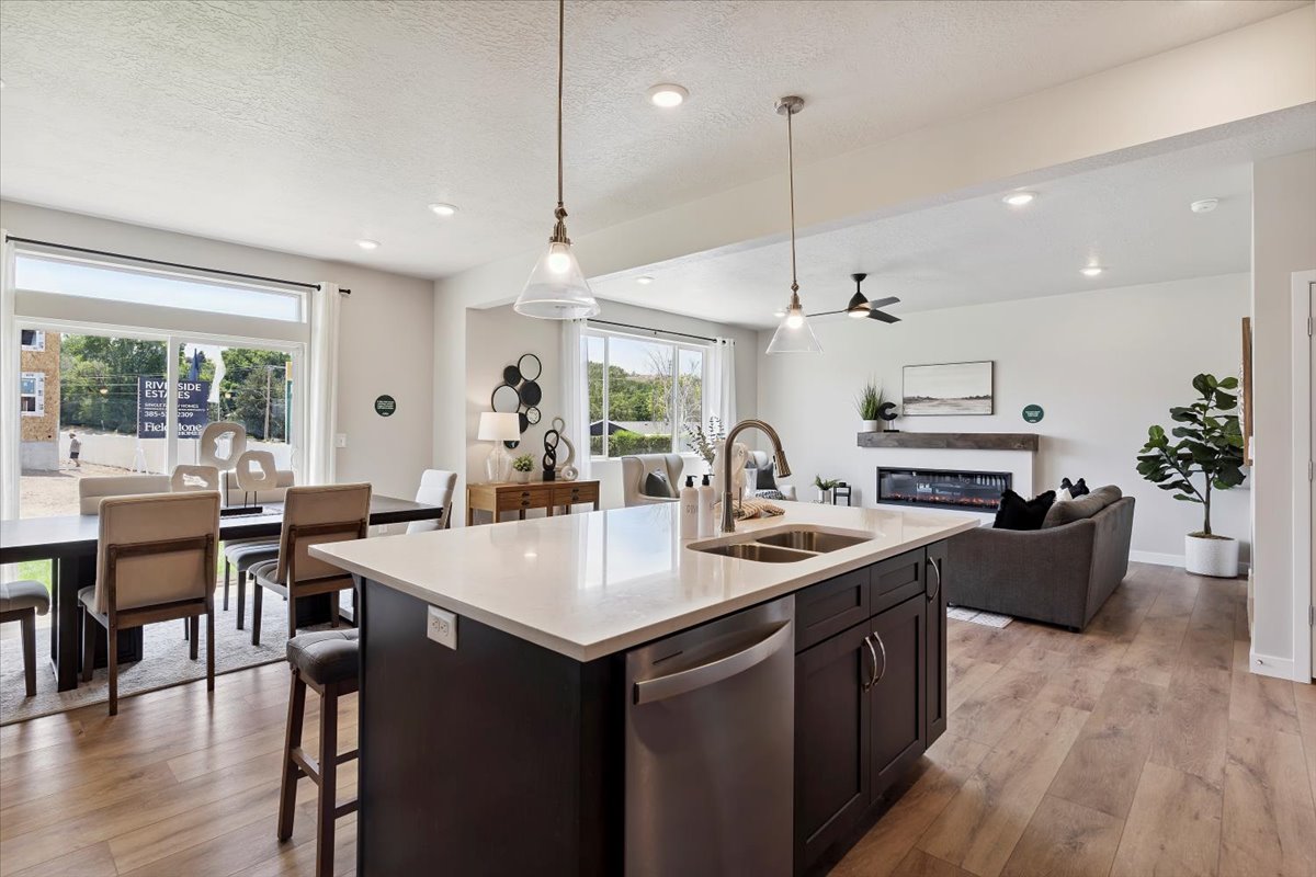 Kitchen island with a light-toned countertop, double basin sink, and stainless steel dishwasher