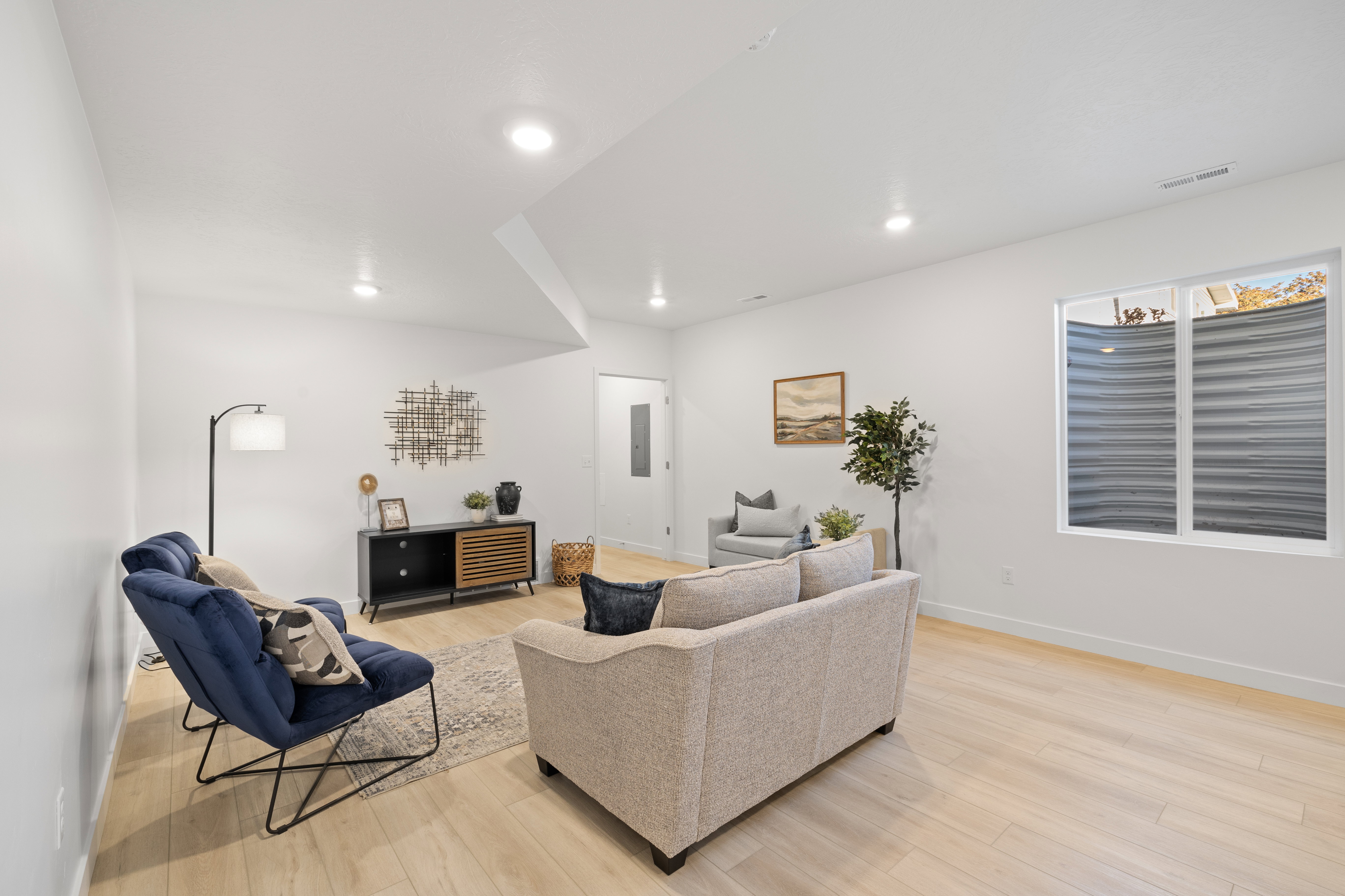 Spacious room featuring light wood-finish flooring and recessed lighting