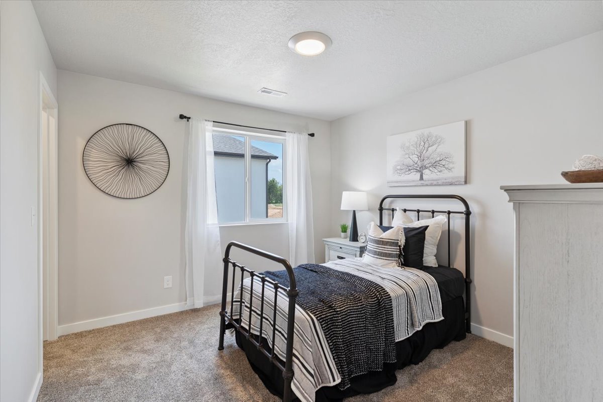 Carpeted bedroom featuring a large window, white trim, and a flush-mount ceiling light fixture