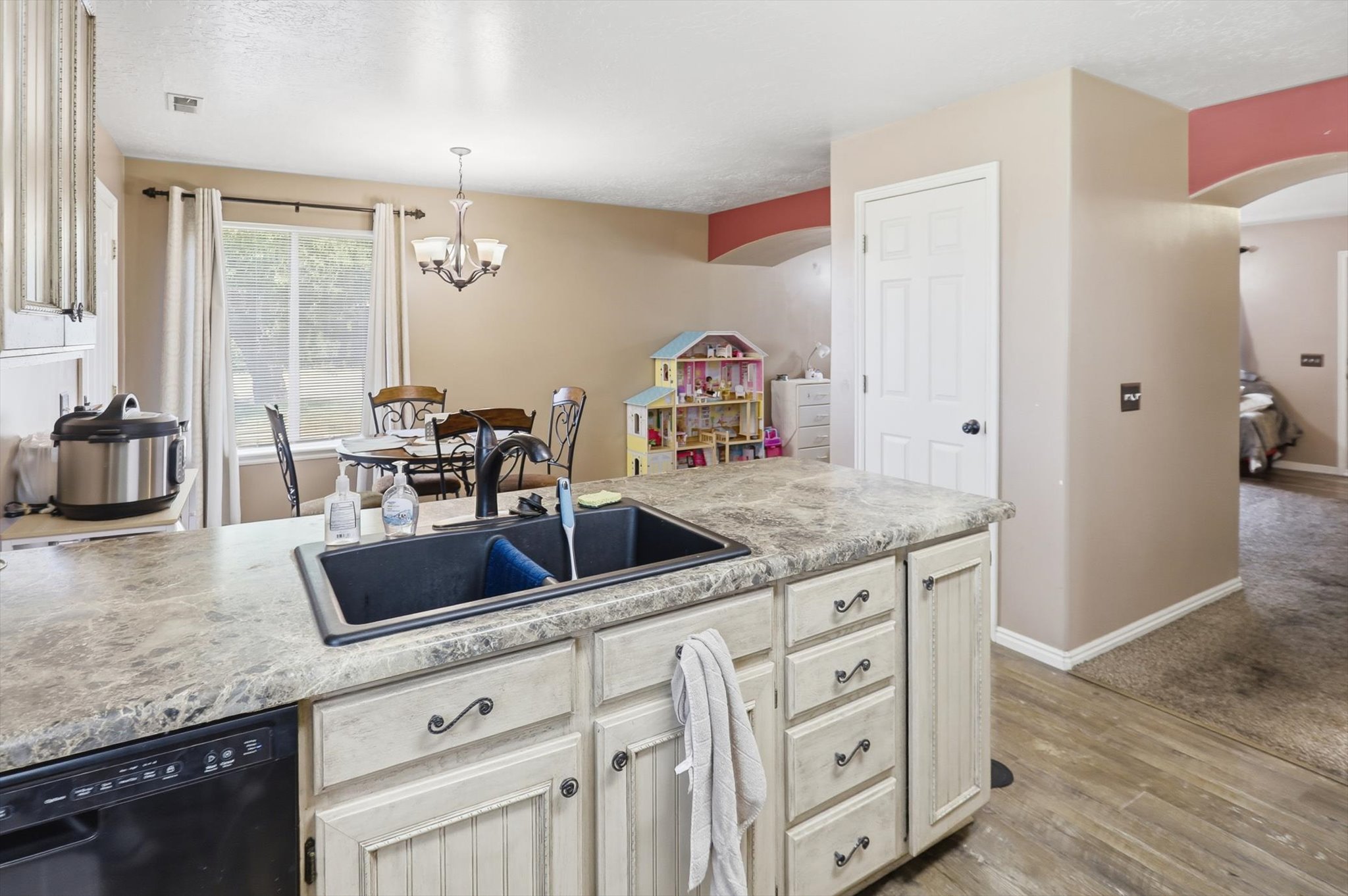 Kitchen island featuring a black composite sink with a gooseneck faucet