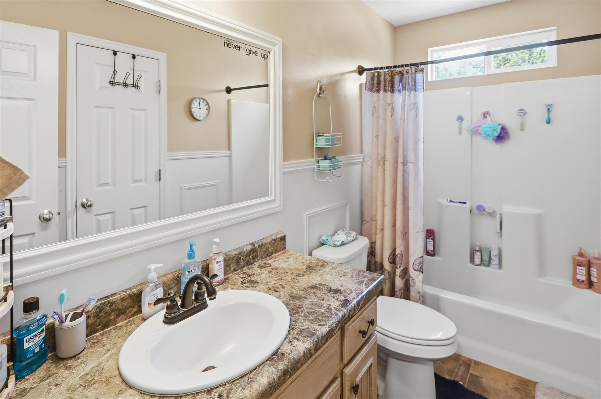 Bathroom featuring a vanity with a cultured marble countertop, an oval undermount sink, and a two-handle bronze faucet