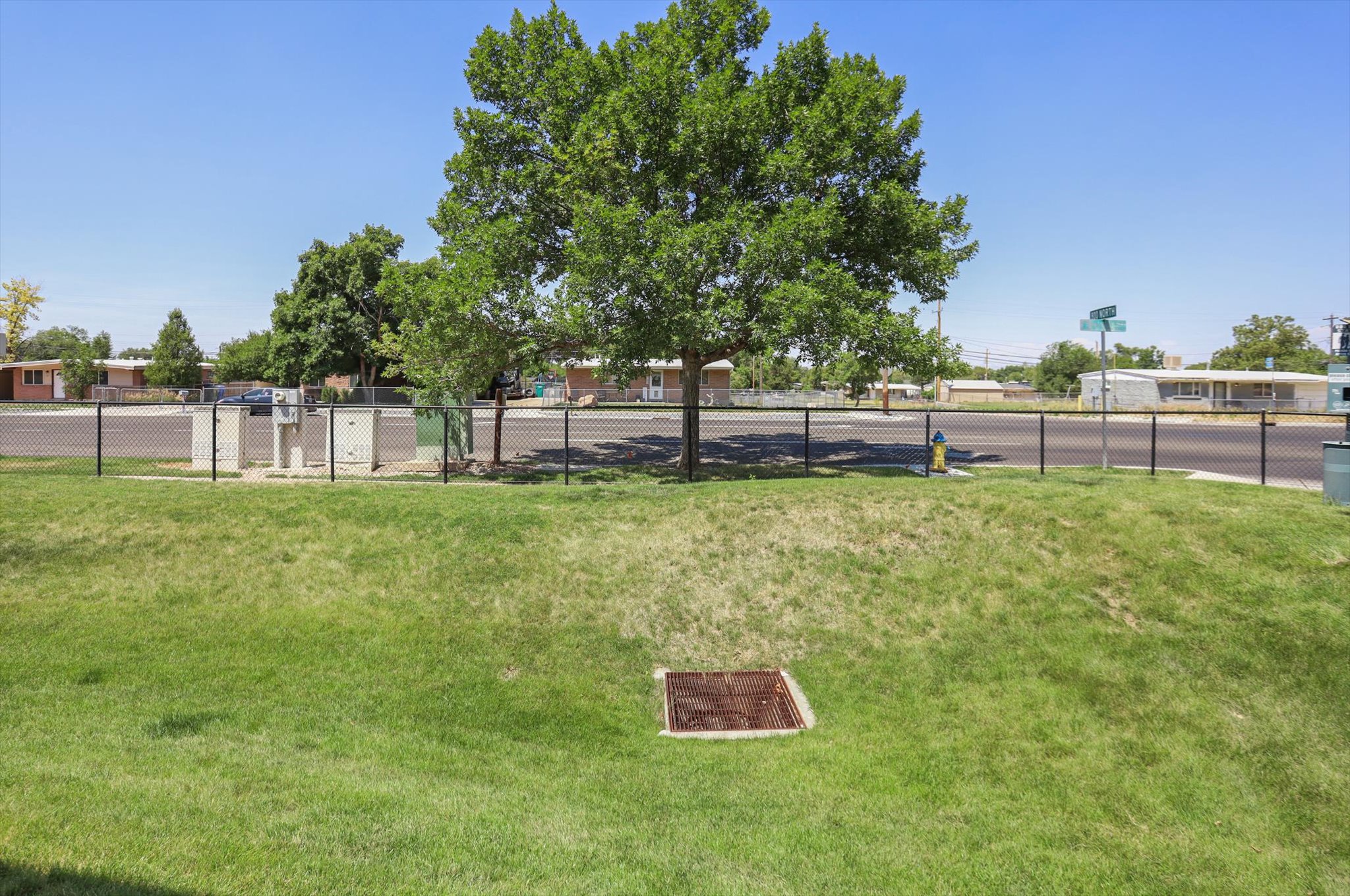 Manicured lawn with a sloped landscape and mature trees