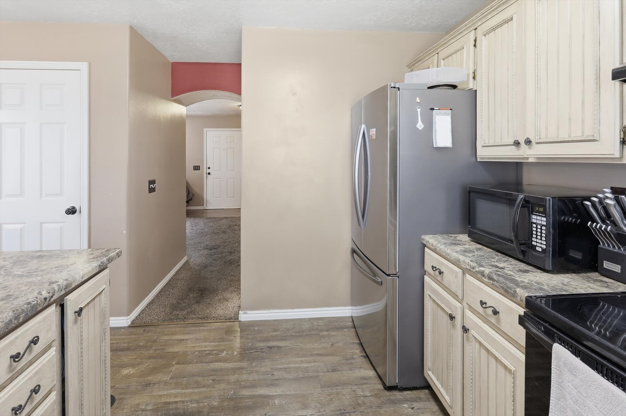 Kitchen featuring wood-finish flooring, light-toned cabinetry, and dark countertop surfaces