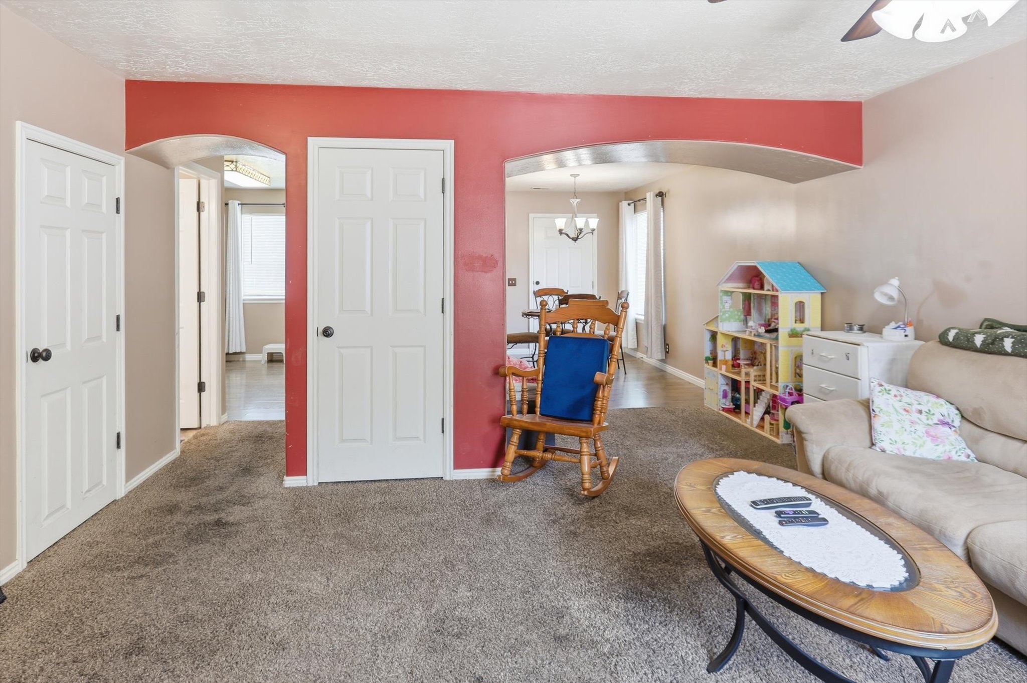 Spacious interior featuring arched doorways, textured ceiling, and five-panel interior doors