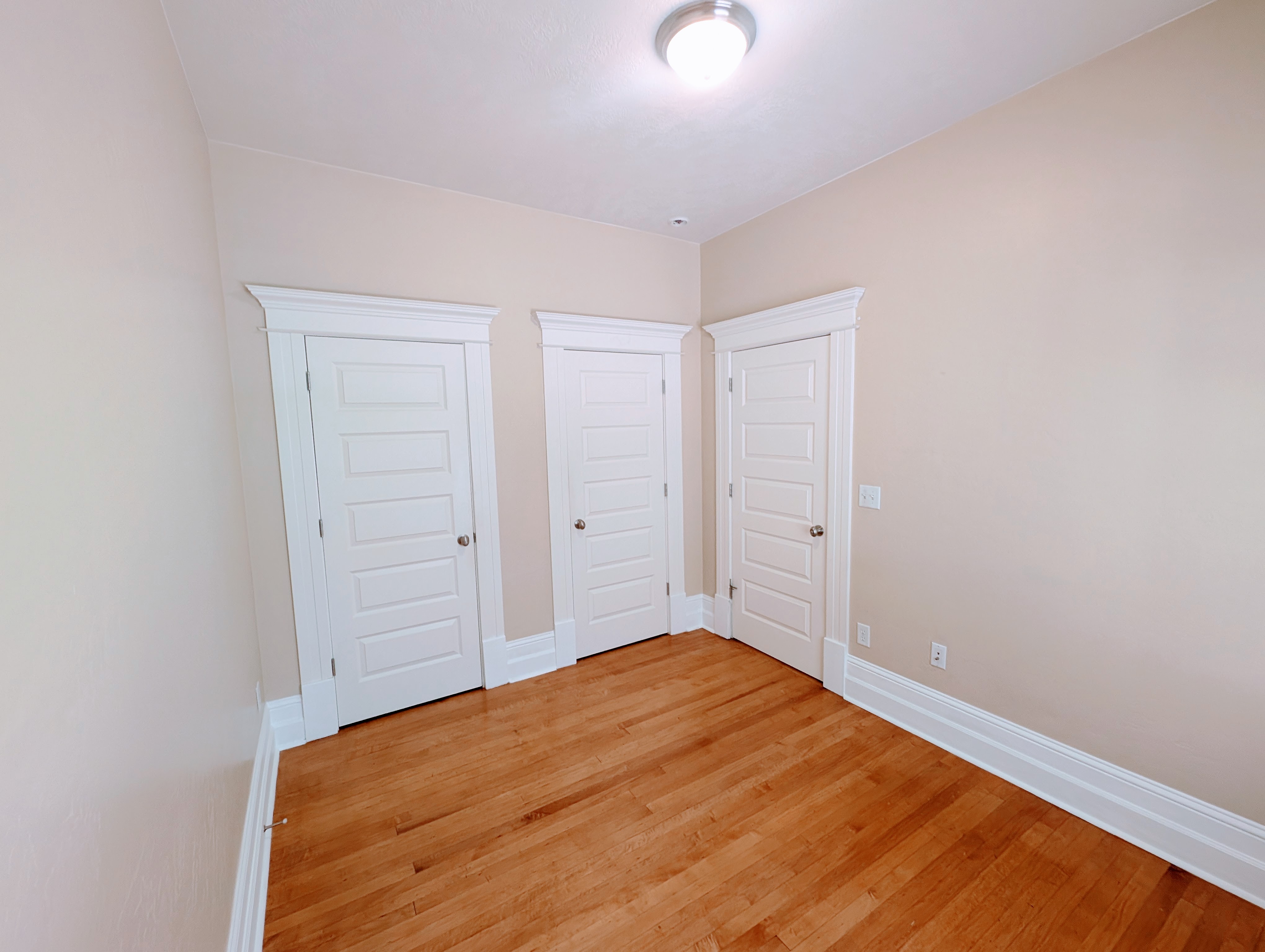 Warm wood-finish flooring complements the neutral wall color