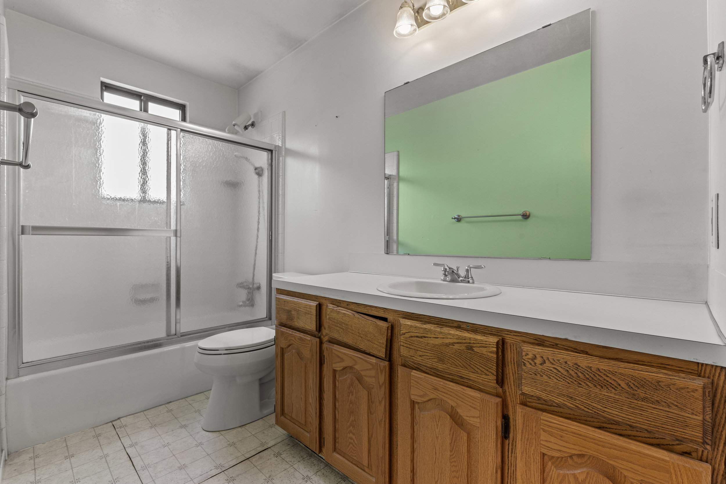 Bathroom featuring a wood-finish vanity with a white countertop and integrated sink