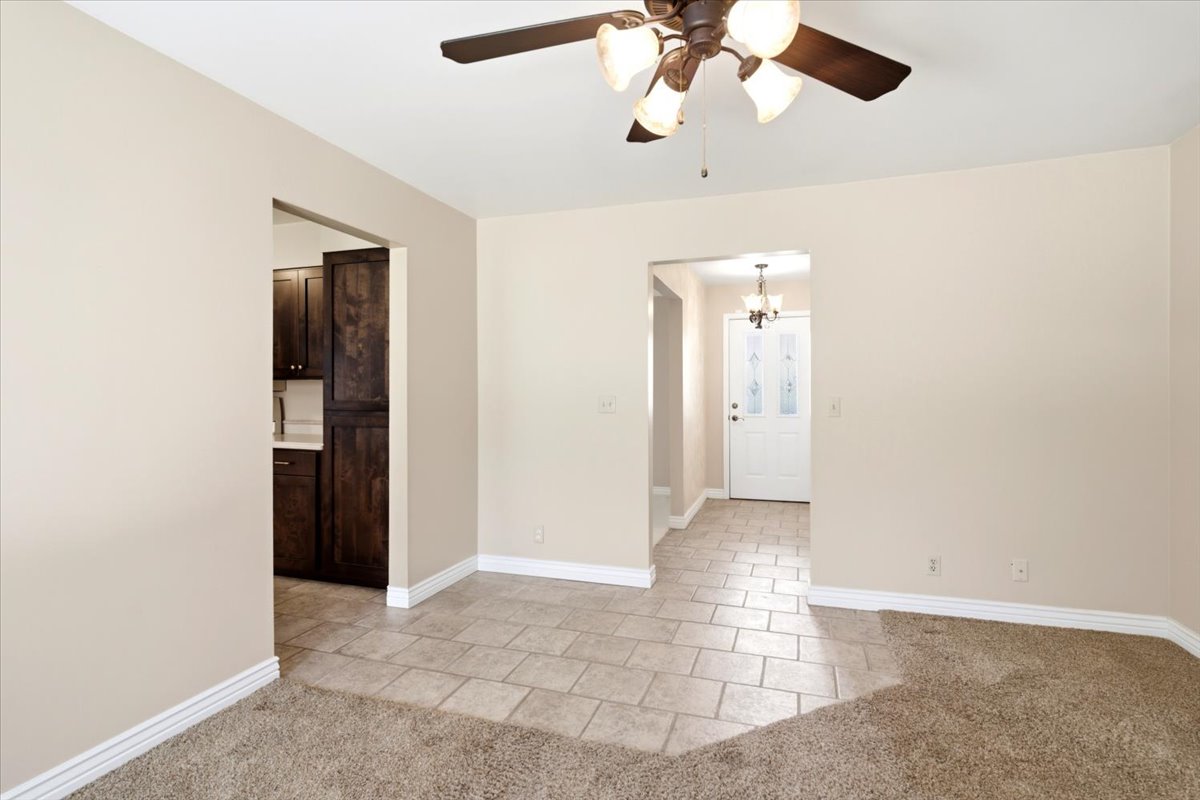 Interior space featuring neutral wall tones, carpeted flooring, and a ceiling fan with integrated lighting