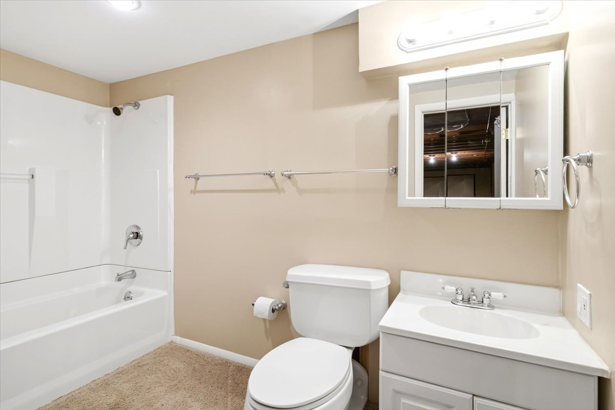 Bathroom with a white tub and shower combination featuring chrome fixtures