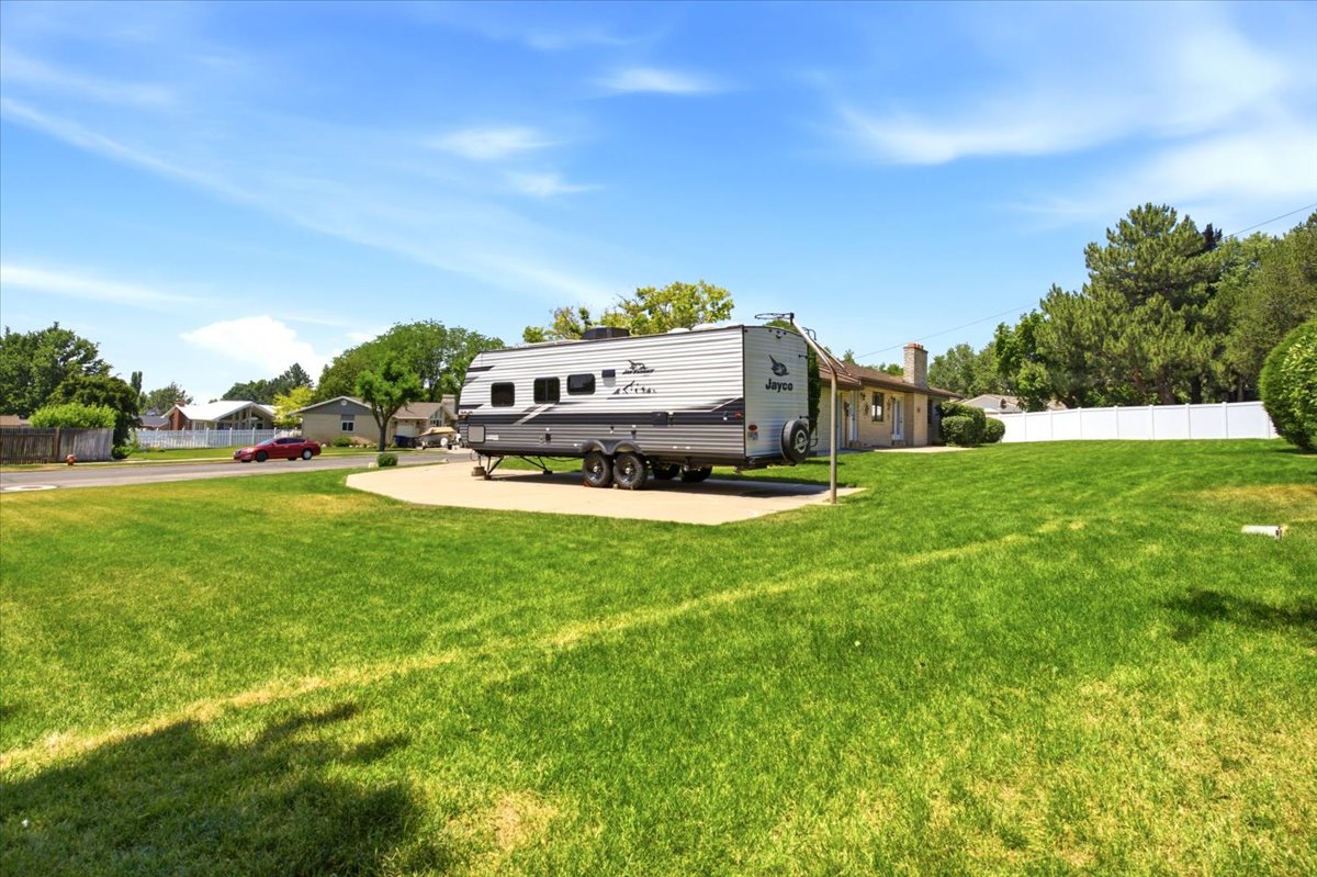 Expansive lawn area featuring a concrete pad for additional parking