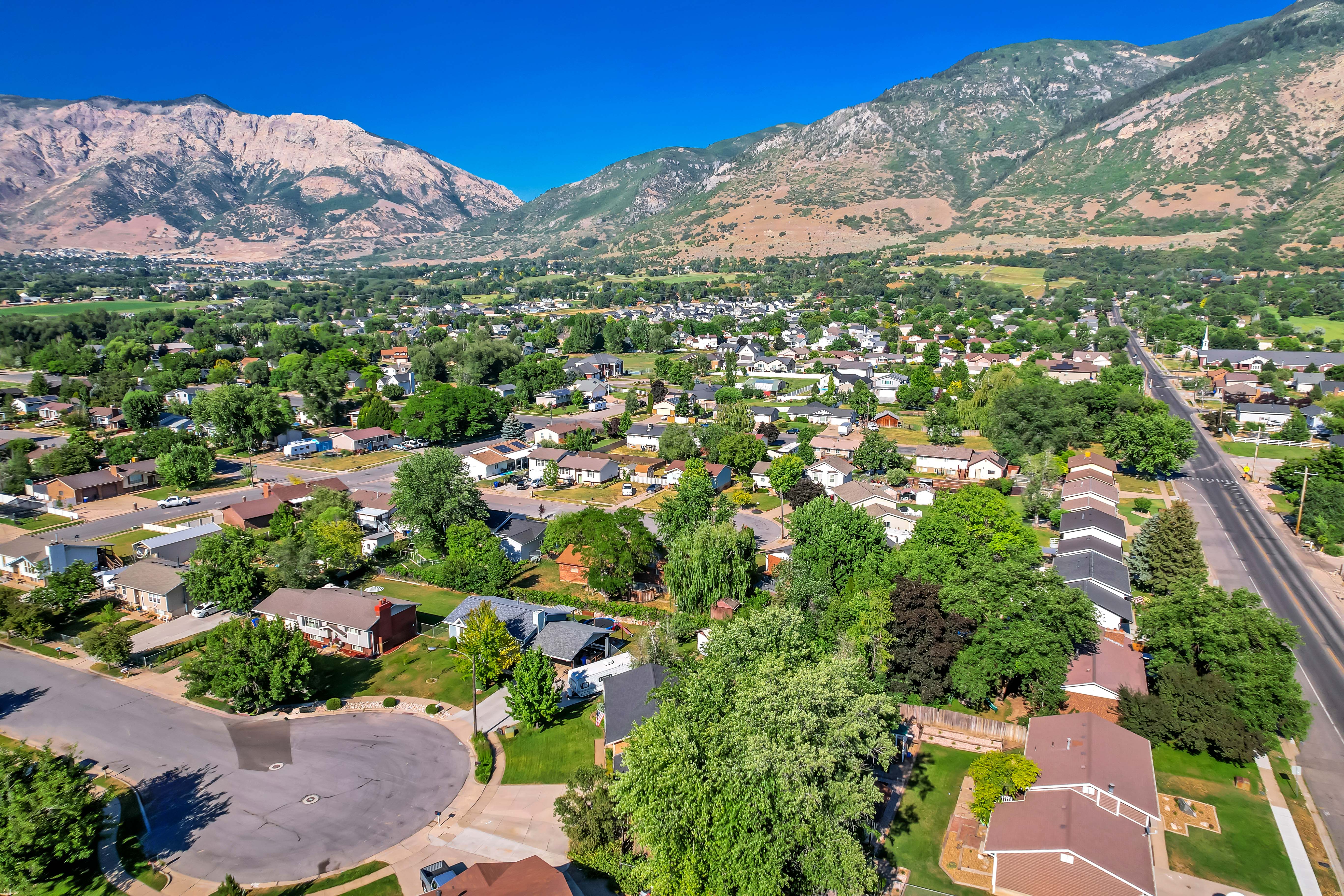 Expansive aerial perspective showcasing a residential community nestled against a mountainous backdrop