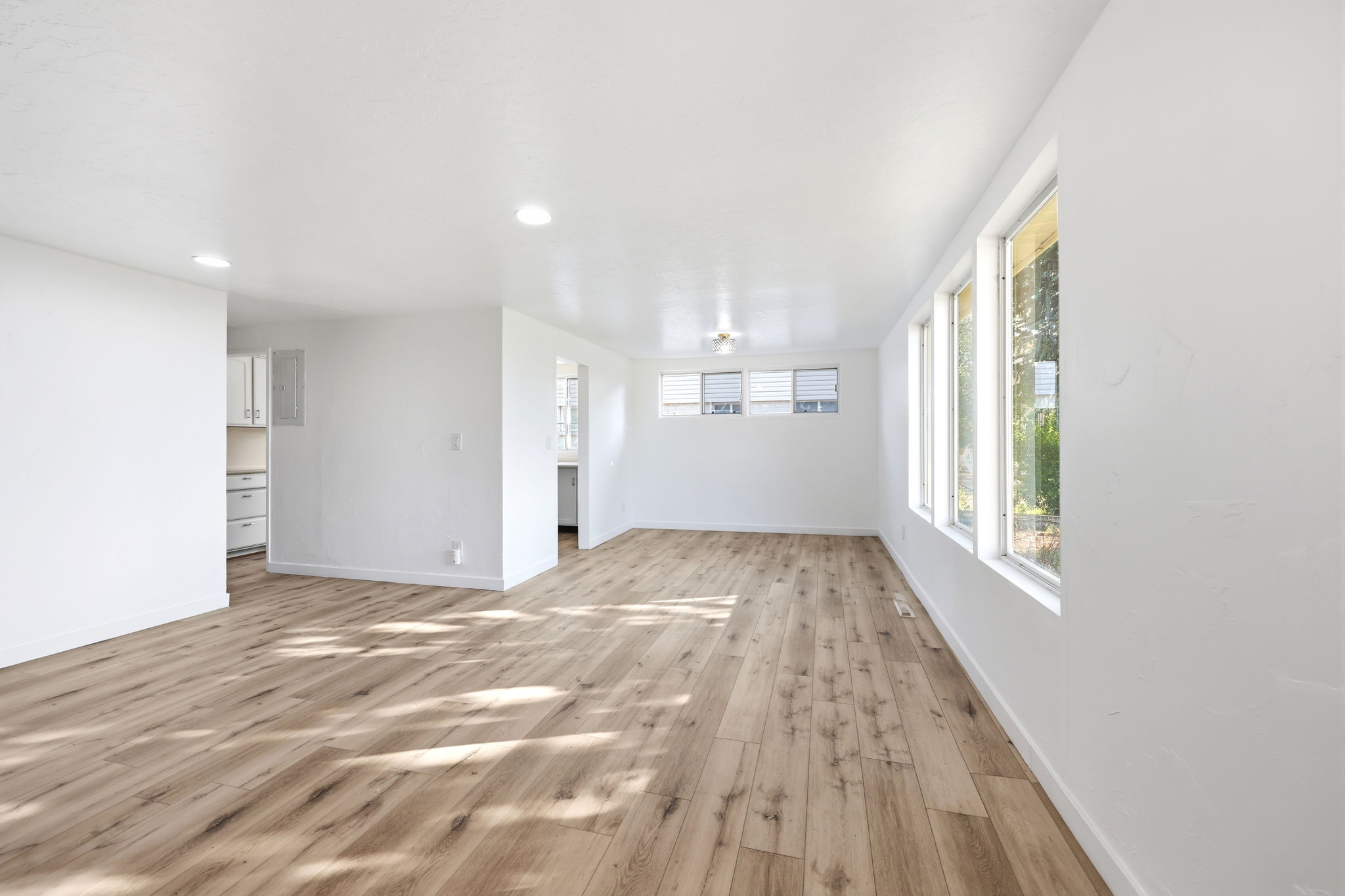 Spacious interior featuring wood-finish flooring, white walls, and recessed lighting