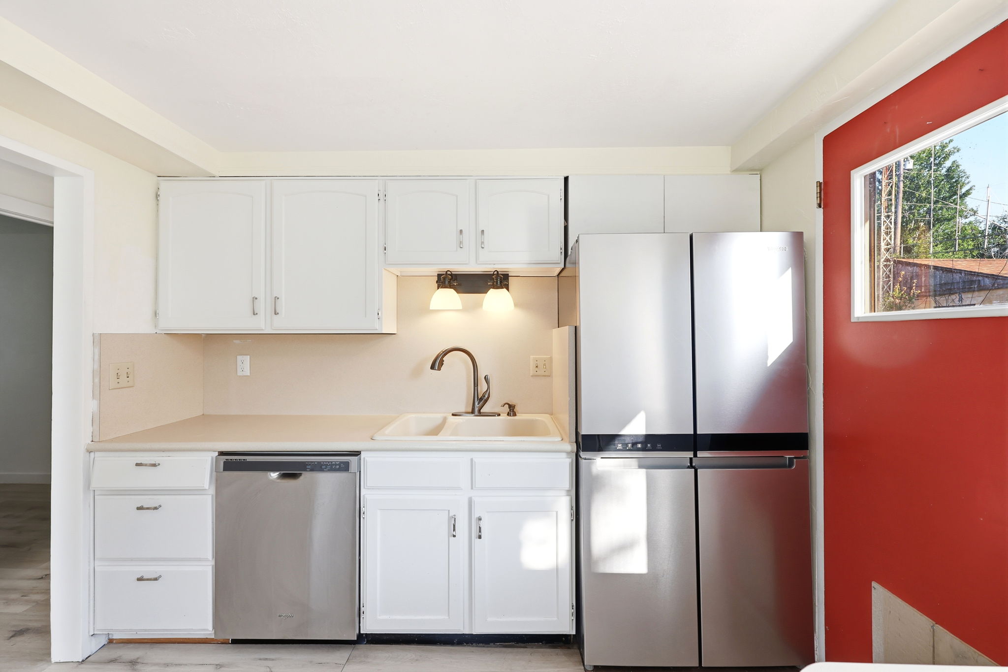Kitchen featuring white cabinetry, light countertops, and a double basin sink with a gooseneck faucet