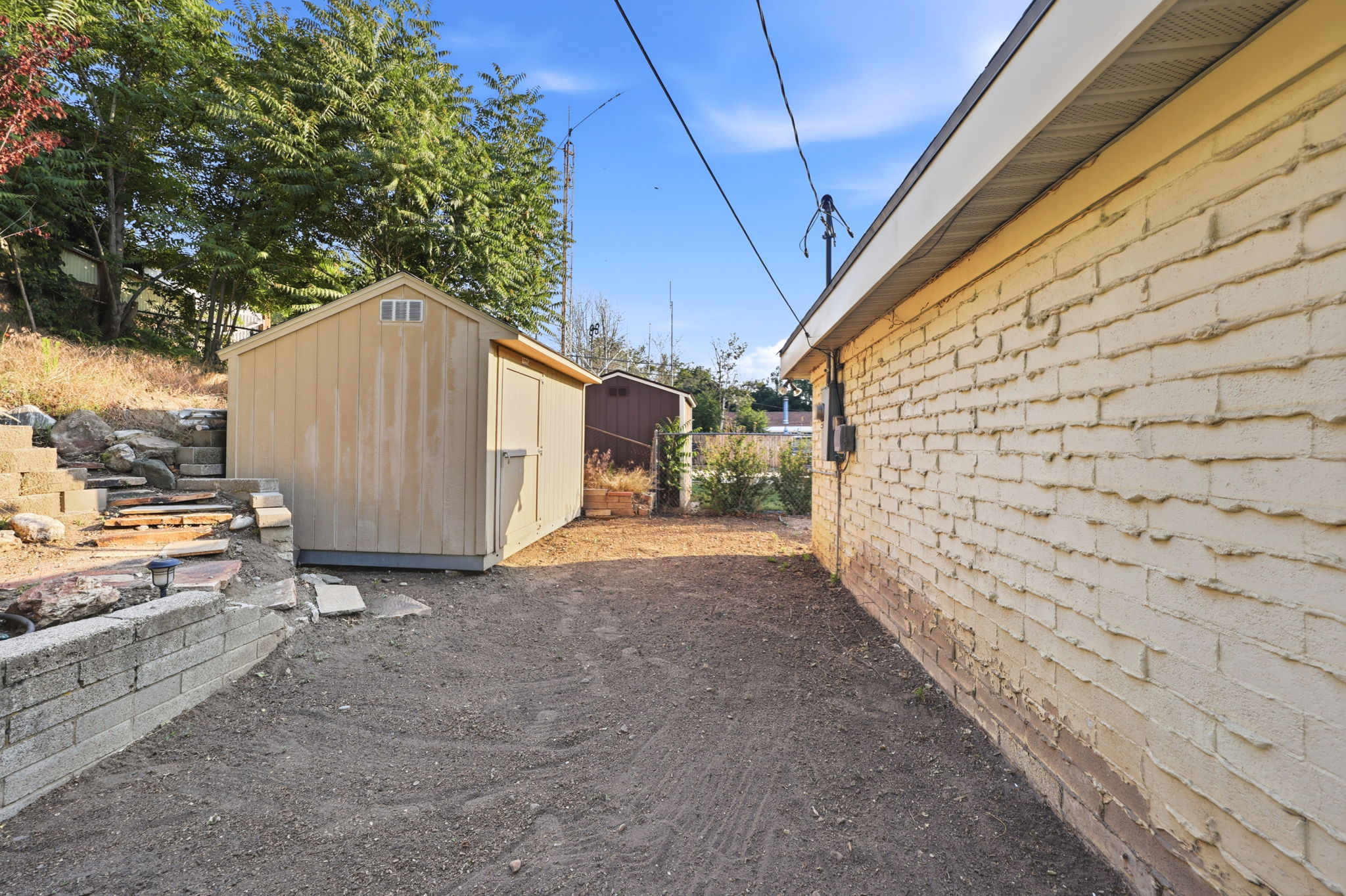 Brick exterior with a detached shed and a retaining wall