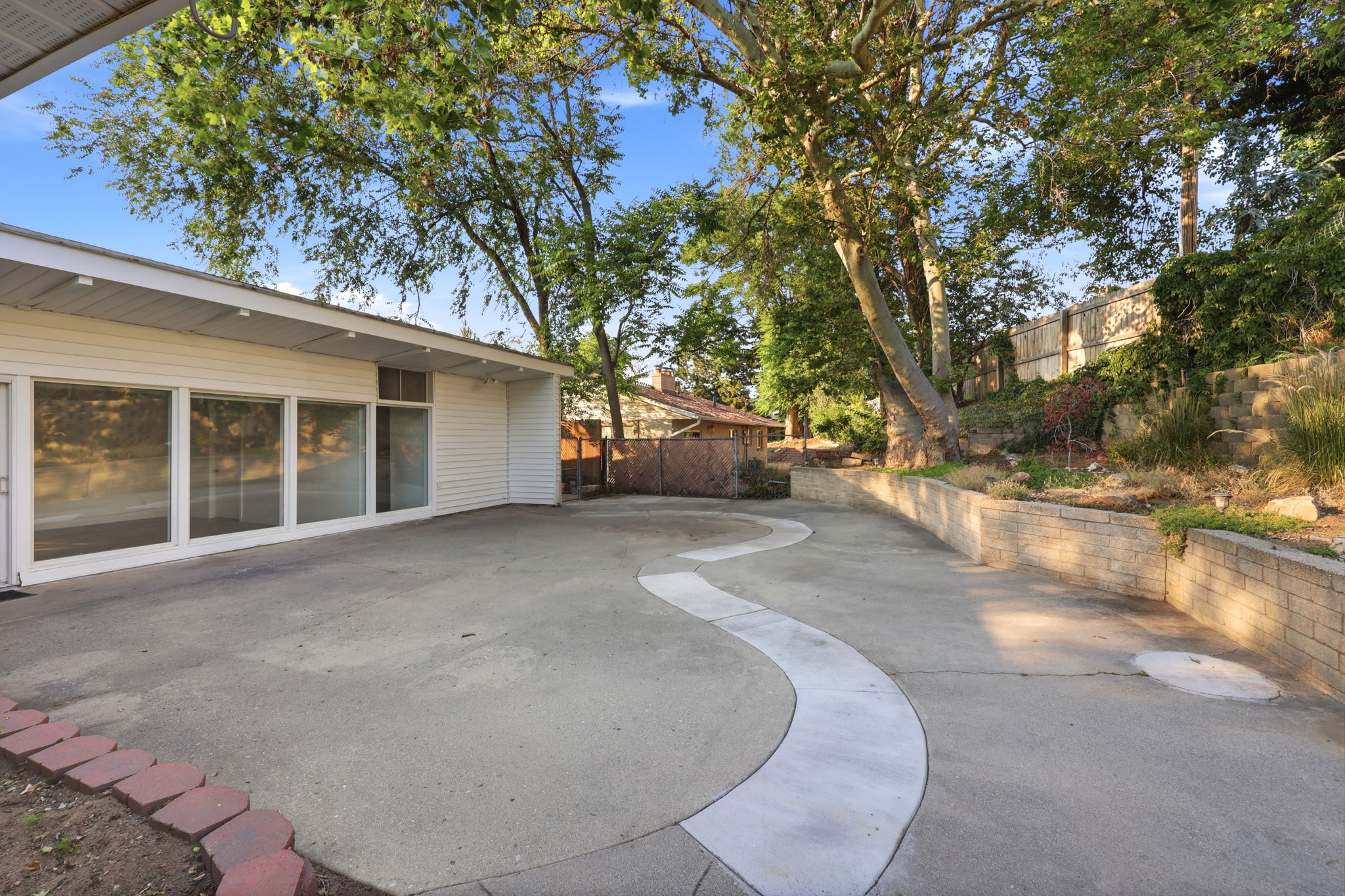 Expansive concrete patio area featuring a decorative curved concrete inlay