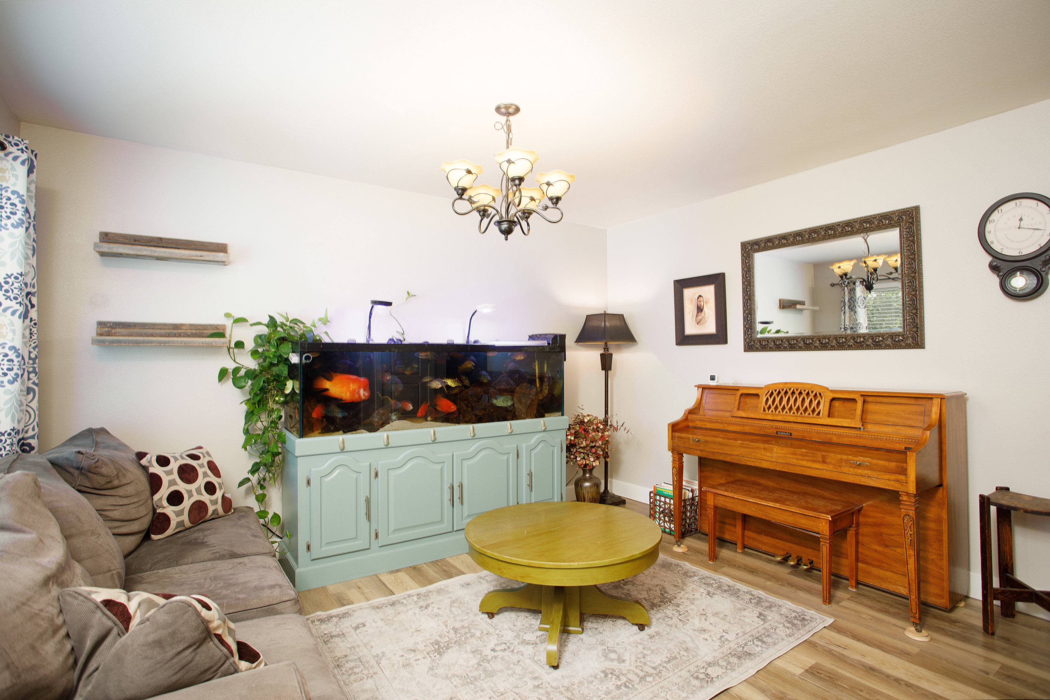 Living area featuring light wood-finish flooring, white walls, and a chandelier light fixture