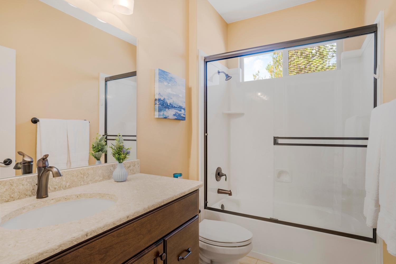 Bathroom featuring a vanity with an integrated sink, a light-toned countertop, and dark wood-finish cabinetry