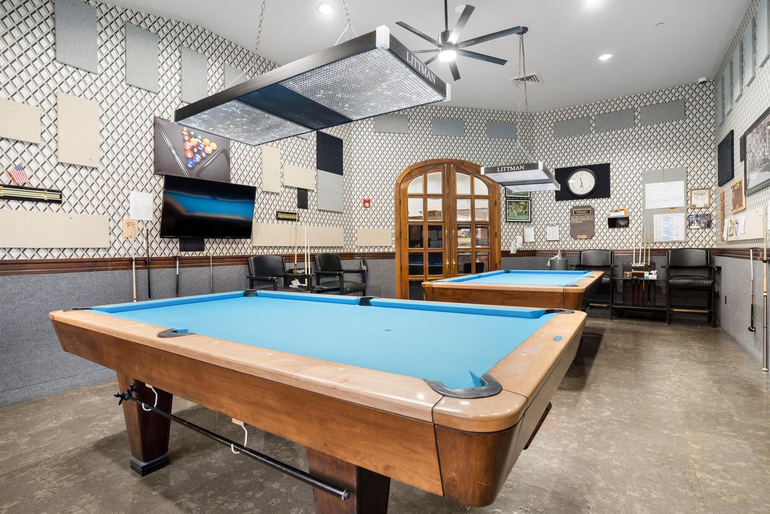 Recreation room featuring two billiards tables with blue felt and wood-finish frames