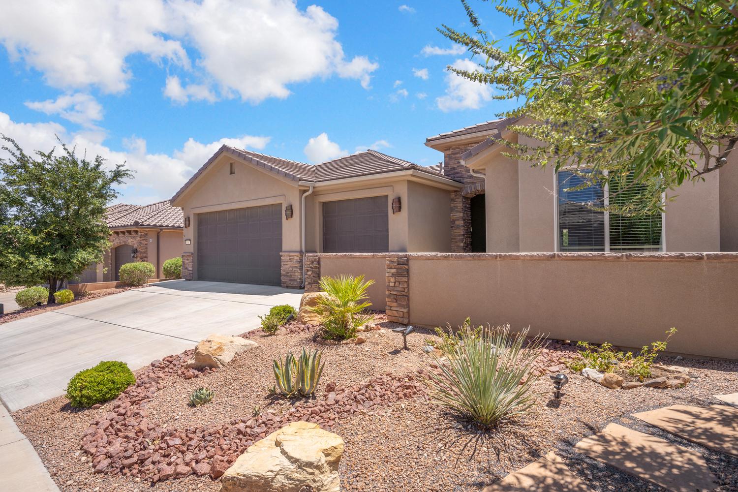 Stucco exterior with stone accents and a concrete driveway