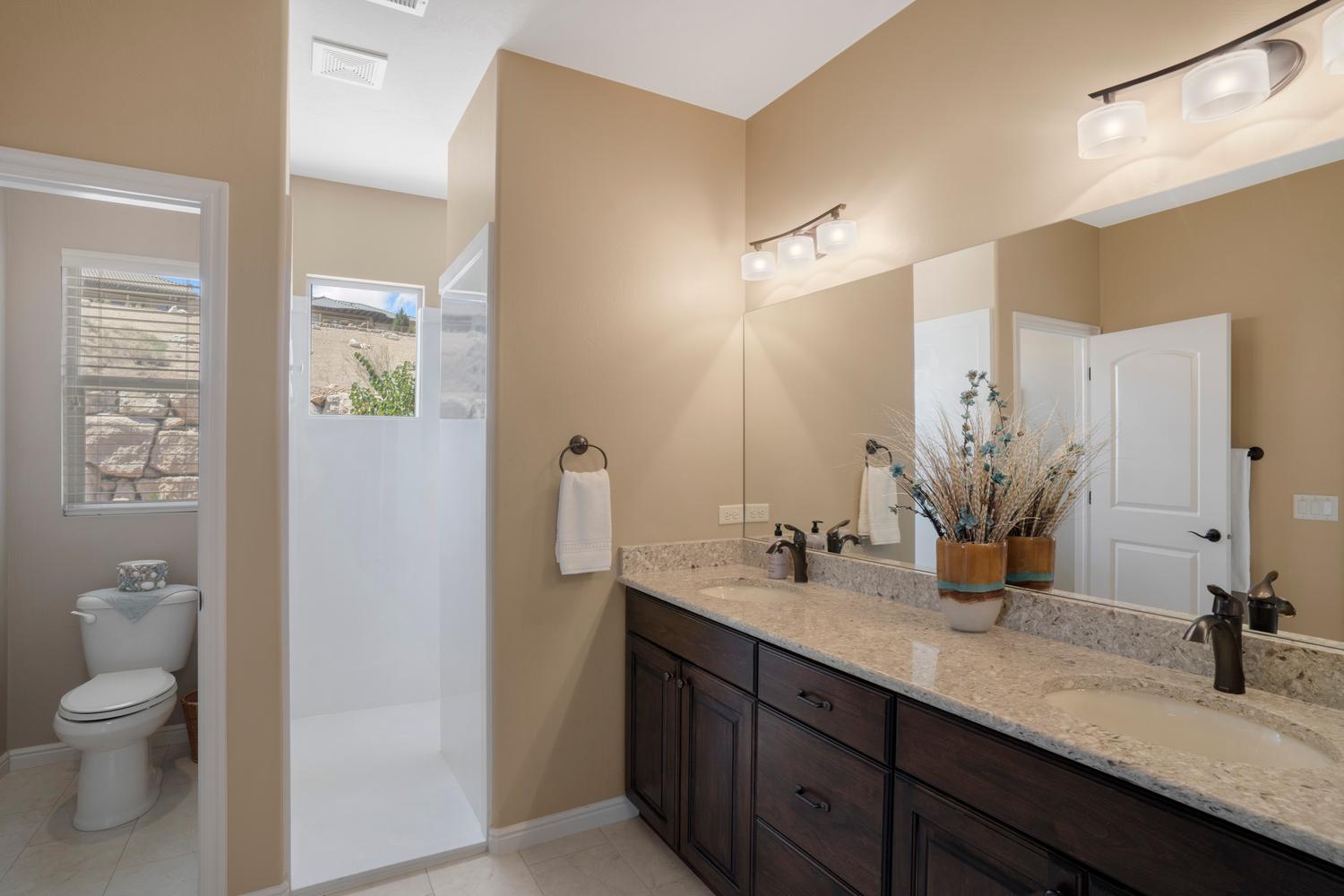 Dual vanity with granite-style countertop and dark wood-finish cabinetry