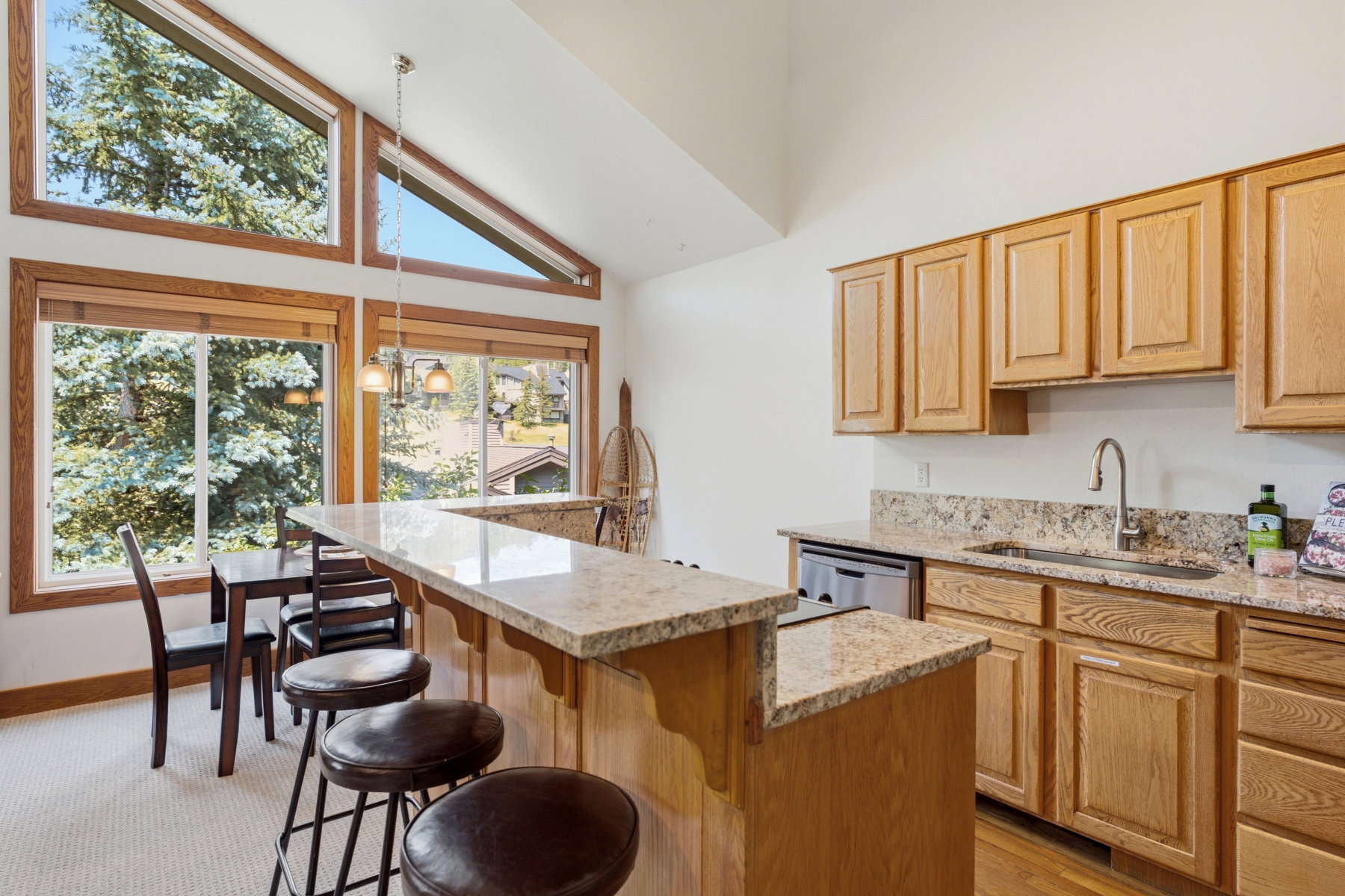Kitchenette featuring a granite-topped peninsula with breakfast bar, wood-finish cabinetry, and stainless steel sink