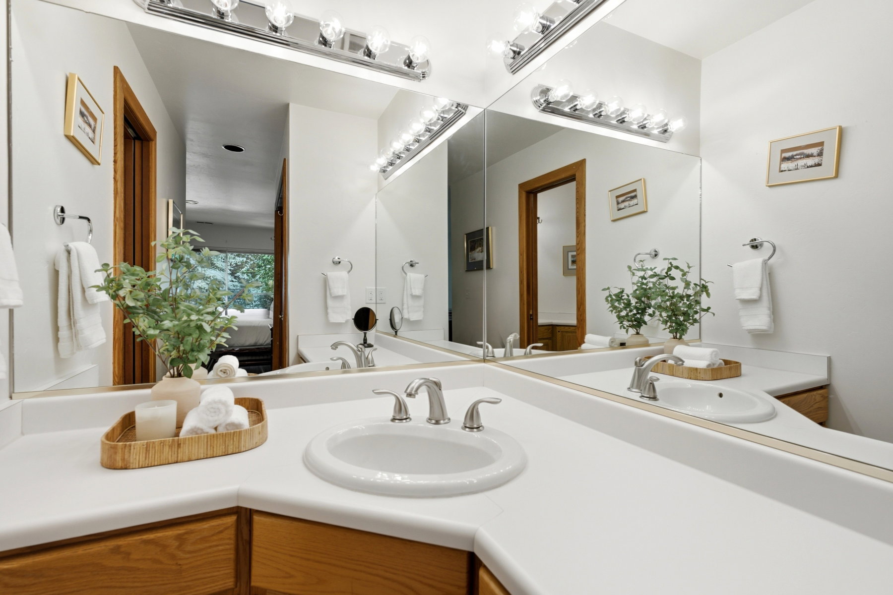 Dual vanity featuring white countertops, undermount sinks, and chrome faucets