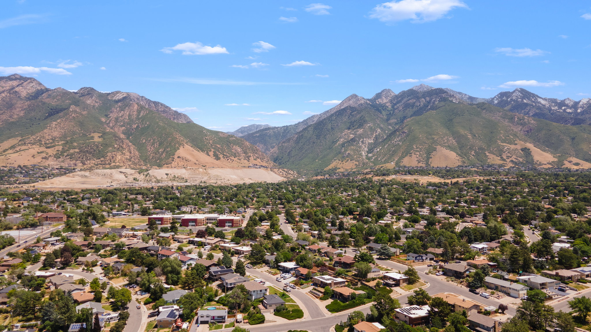 Expansive neighborhood with mature trees and mountain backdrop