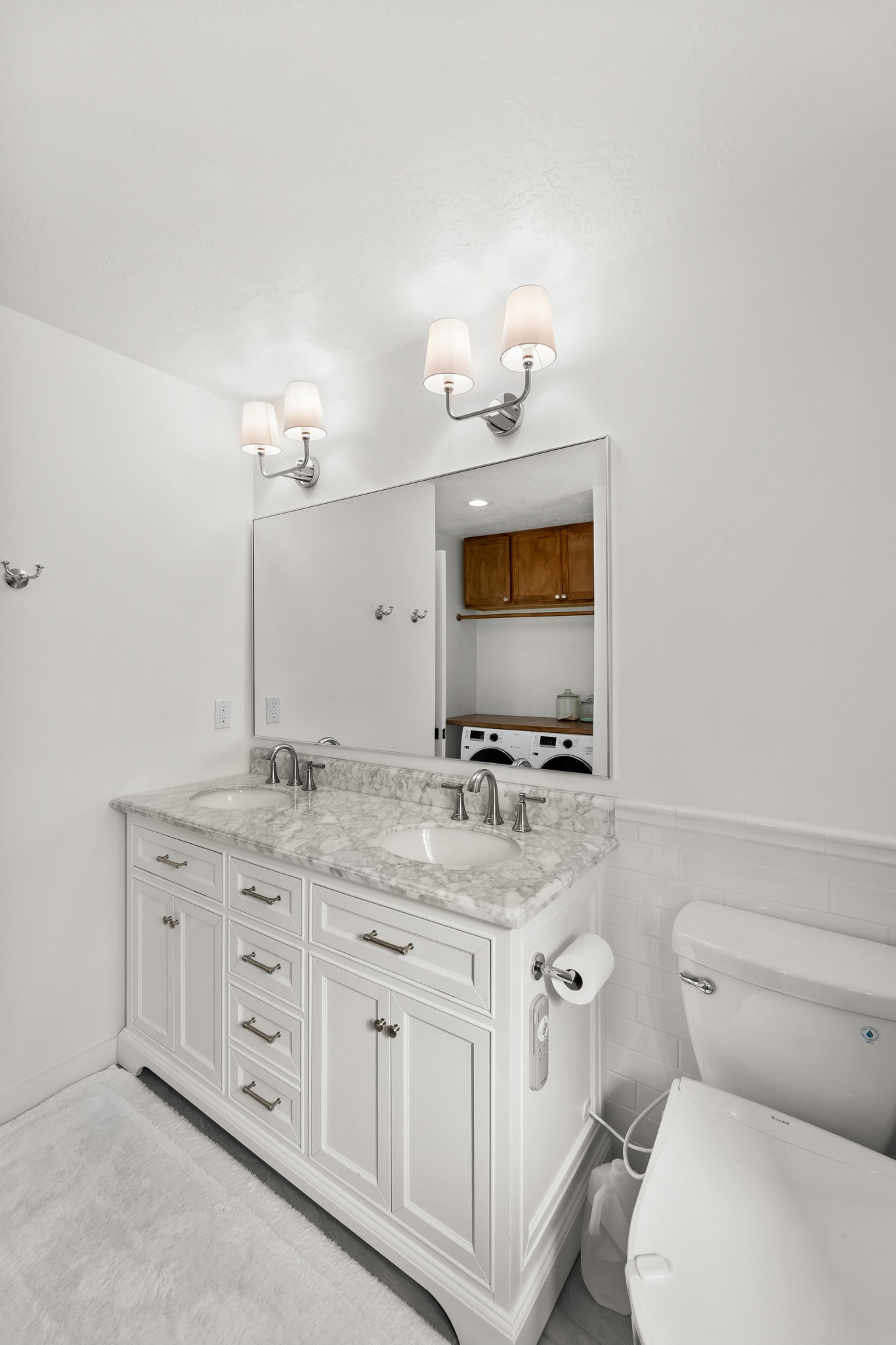 Dual vanity with white cabinetry, a light-toned countertop, and undermount sinks
