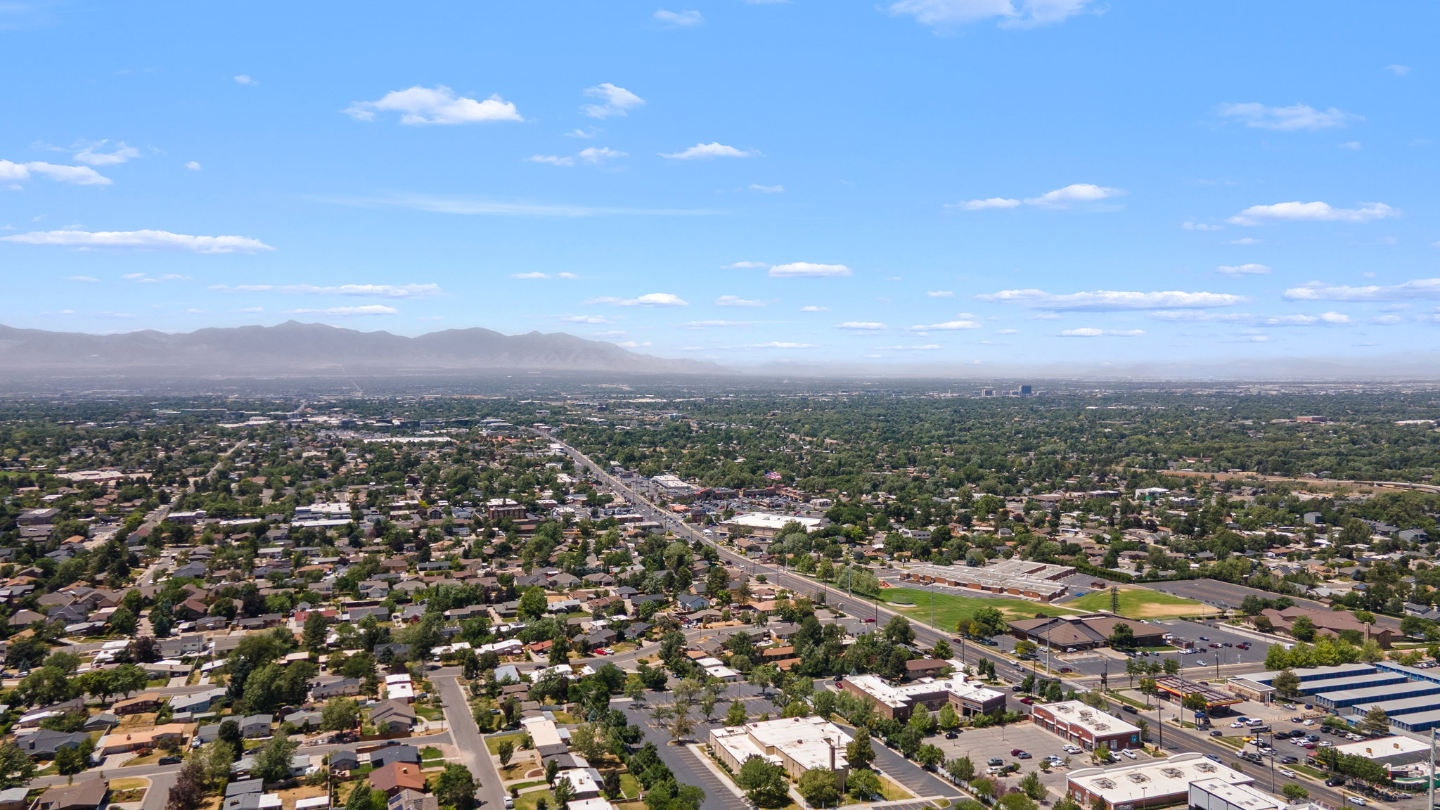 Expansive aerial panorama showcasing a dense residential community and commercial properties