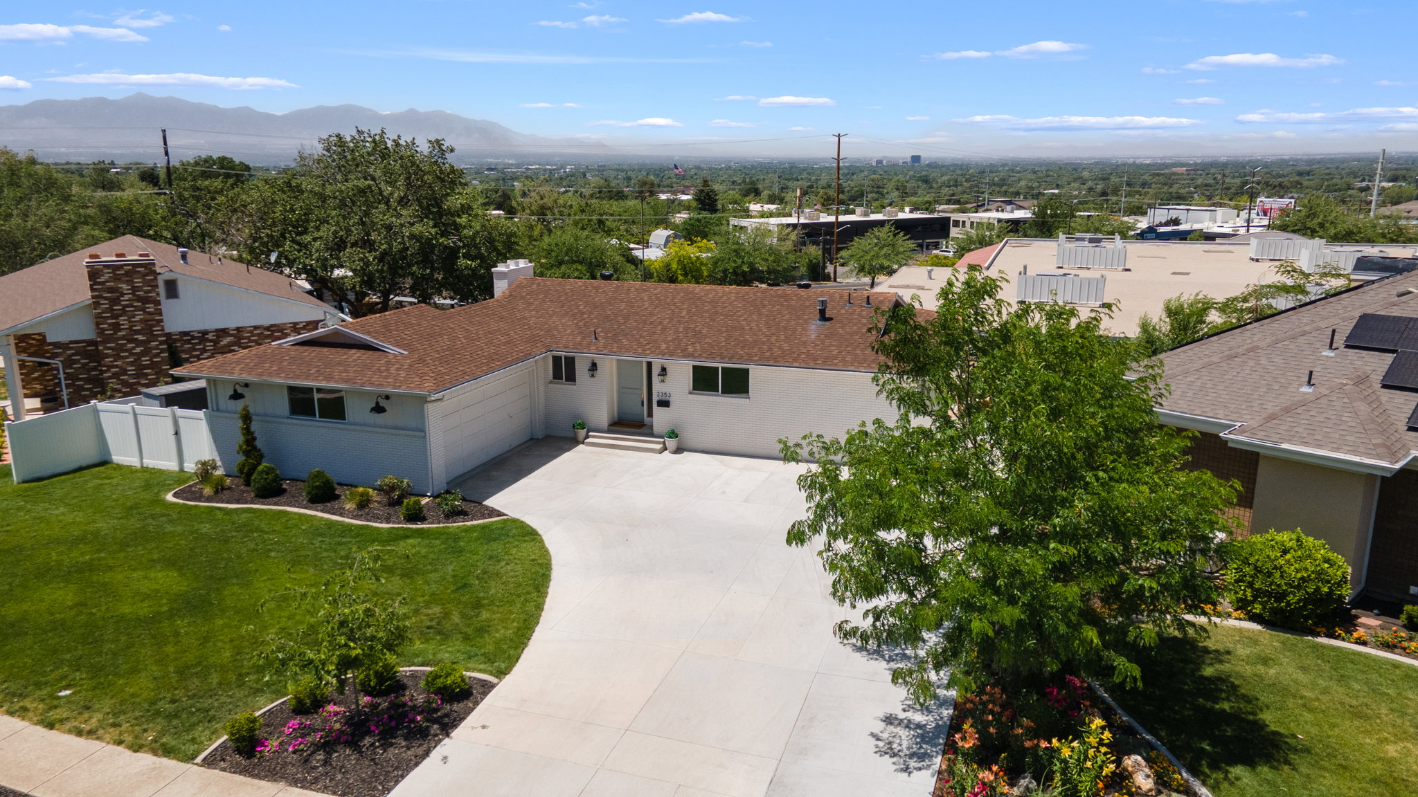 Ranch-style residence featuring a brown shingle roof, a white exterior, and a two-car garage