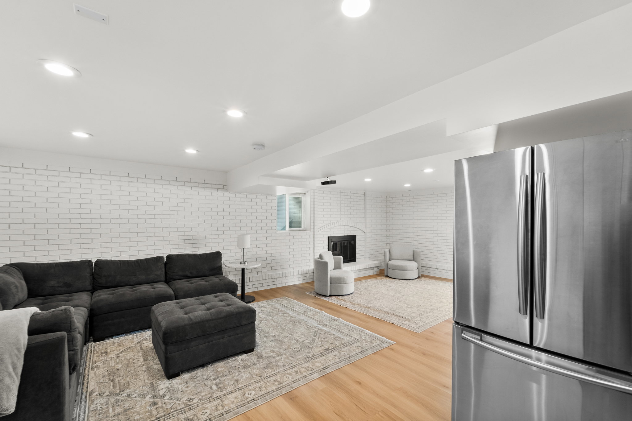 Spacious living area featuring light wood-finish flooring and recessed lighting