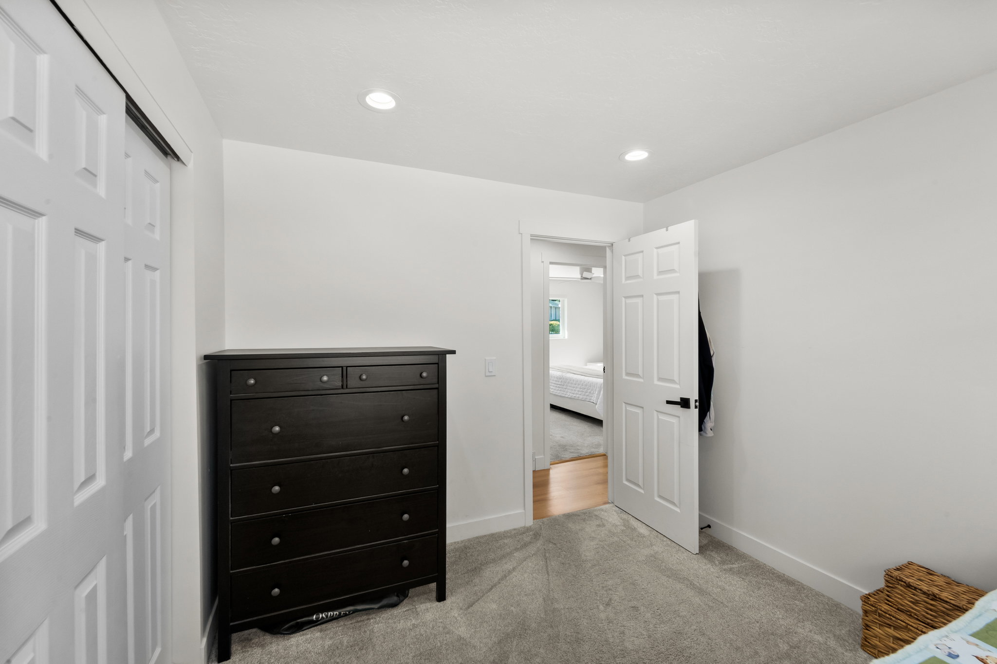 Light gray carpeted flooring paired with crisp white walls and recessed lighting