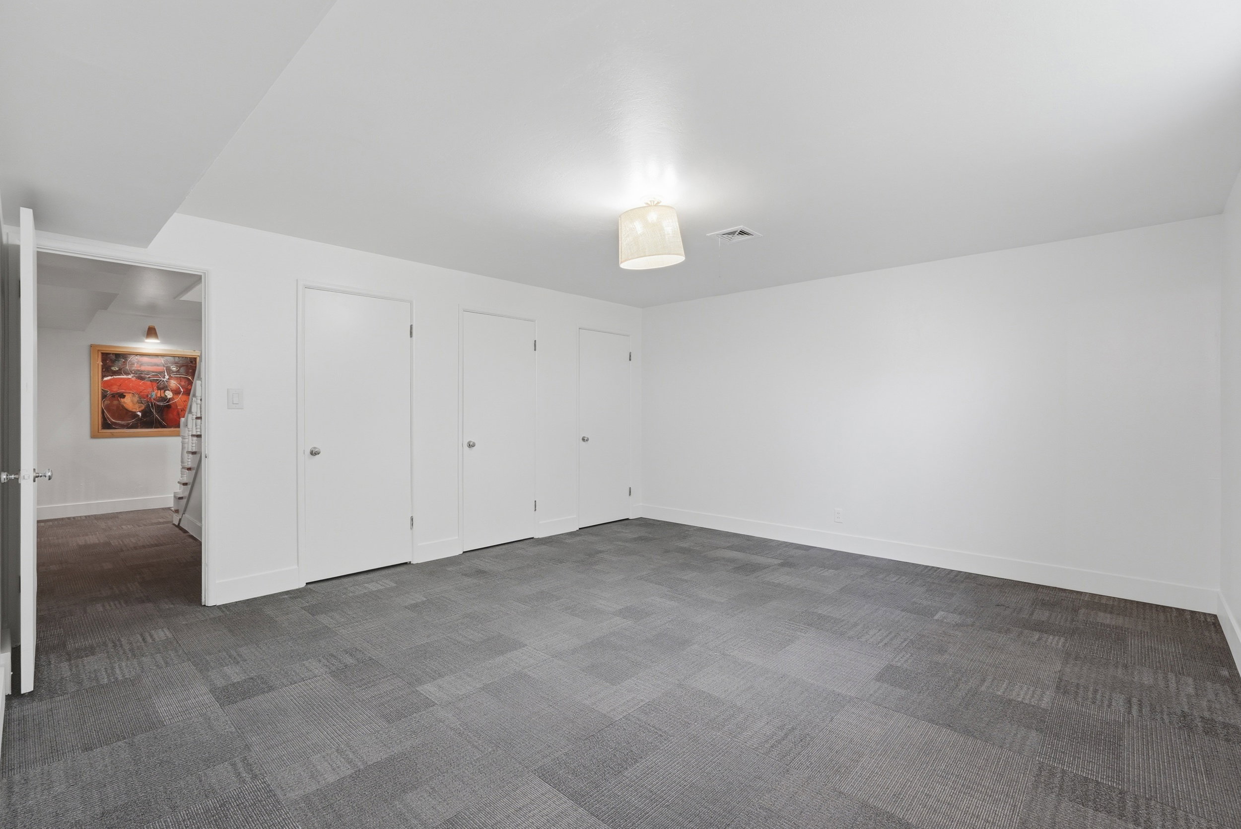 Bedroom 4 with featuring patterned gray carpet tiles, crisp white walls, and a contemporary ceiling light fixture