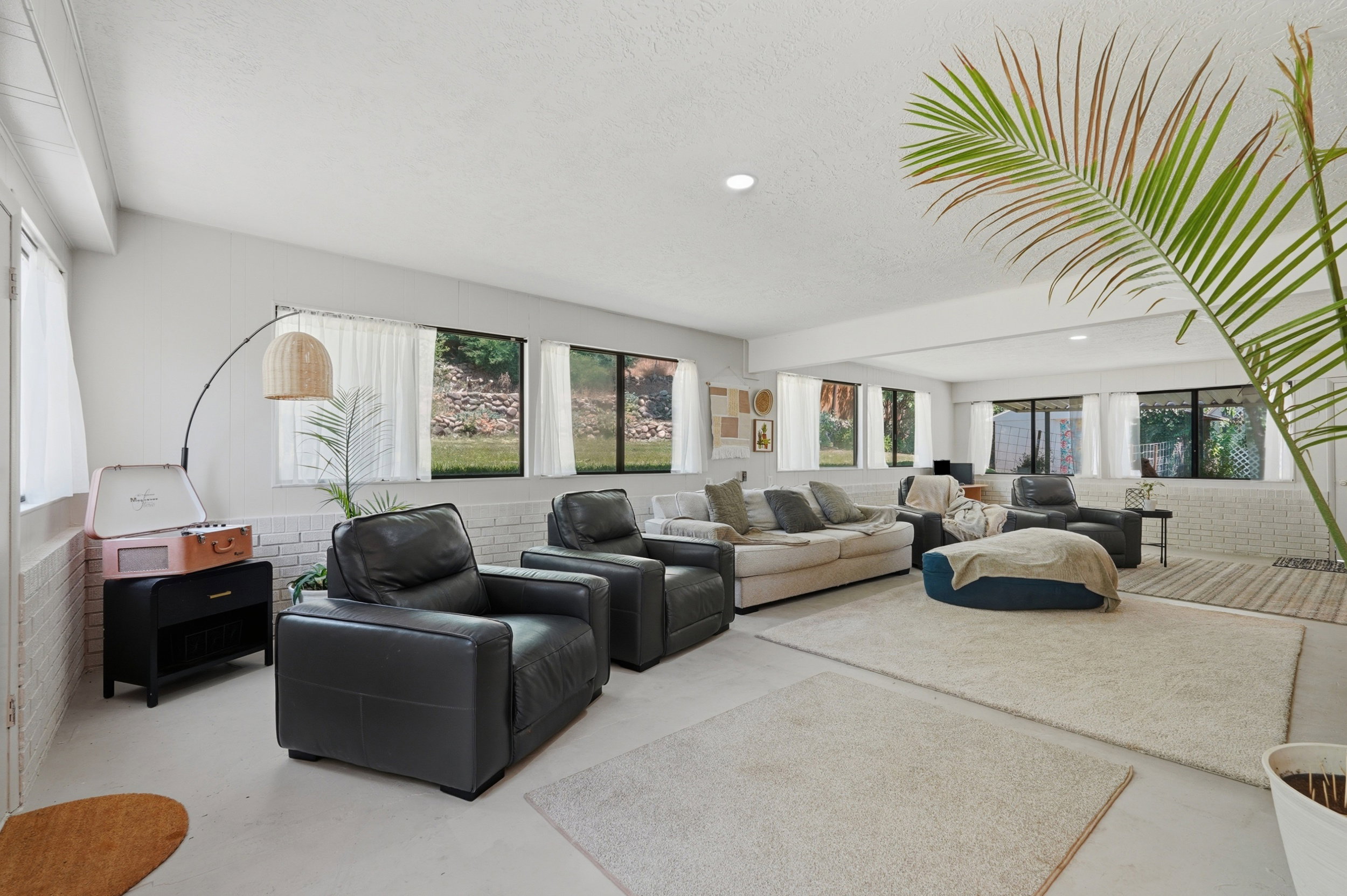 Spacious room featuring multiple windows with outdoor views, light-colored walls, and recessed lighting