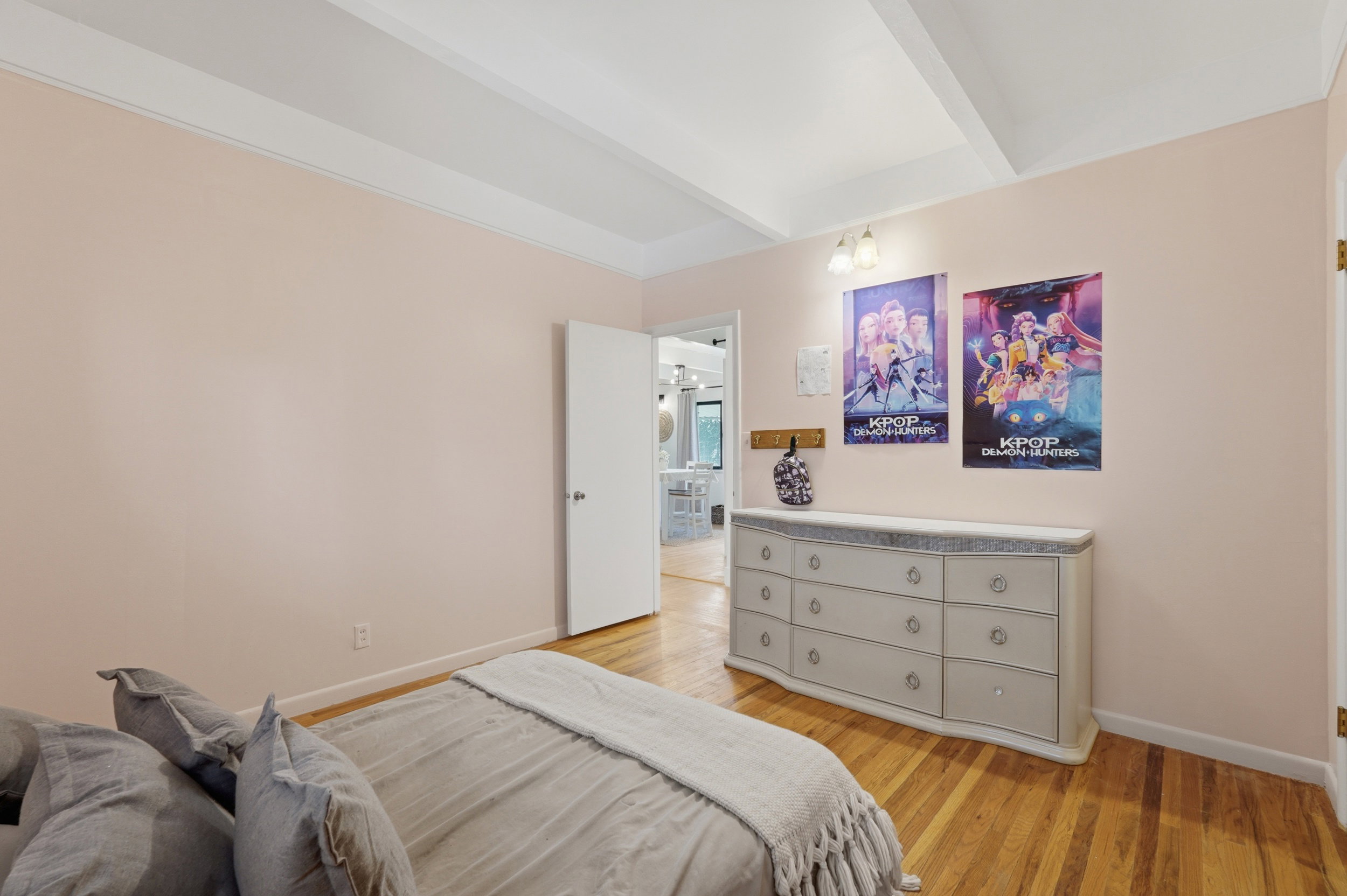 Bedroom 3 with featuring wood-finish flooring, light-toned walls, and a beamed ceiling